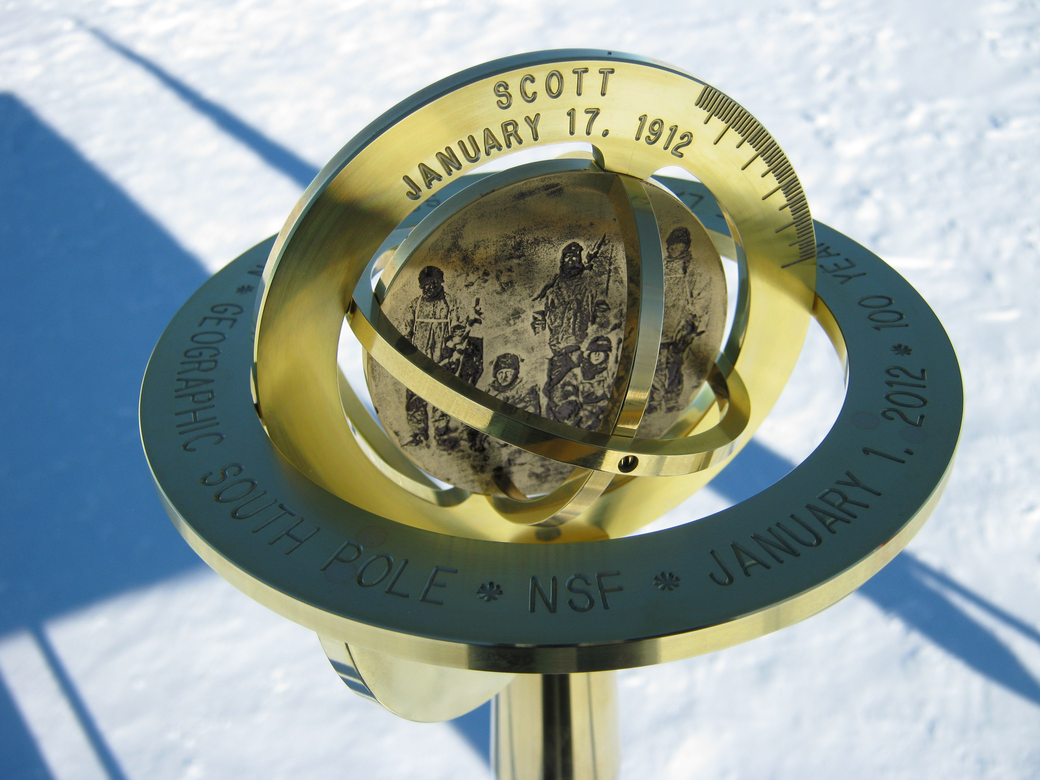 Brass pole marker stands in the snow.
