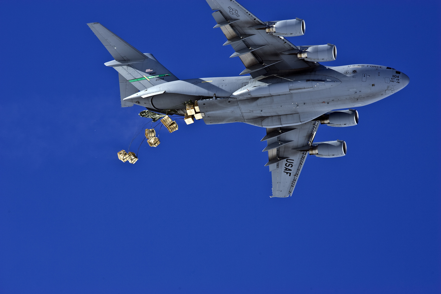 A jet releases cargo with parachutes.