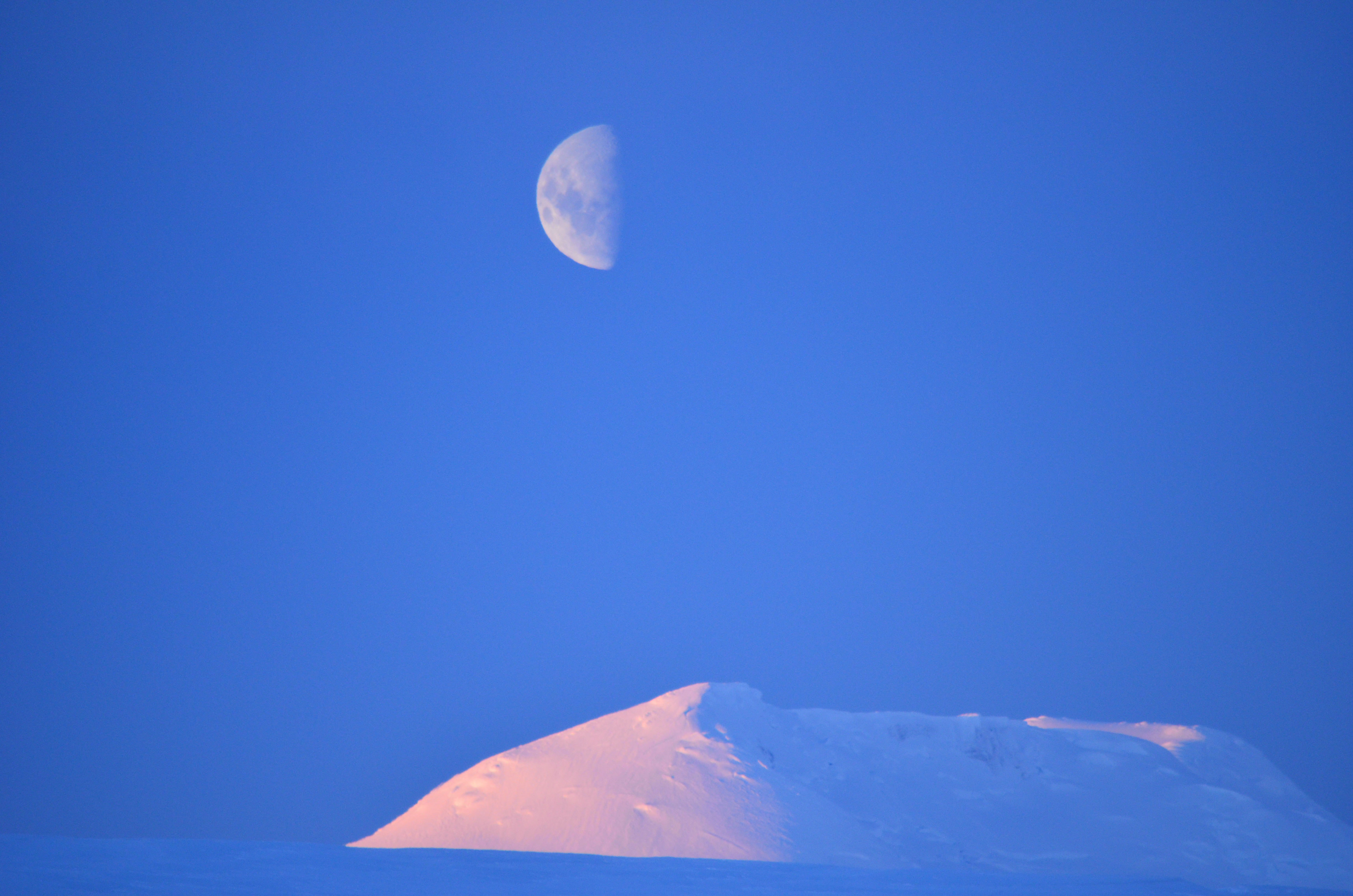Moon over snowy hill.