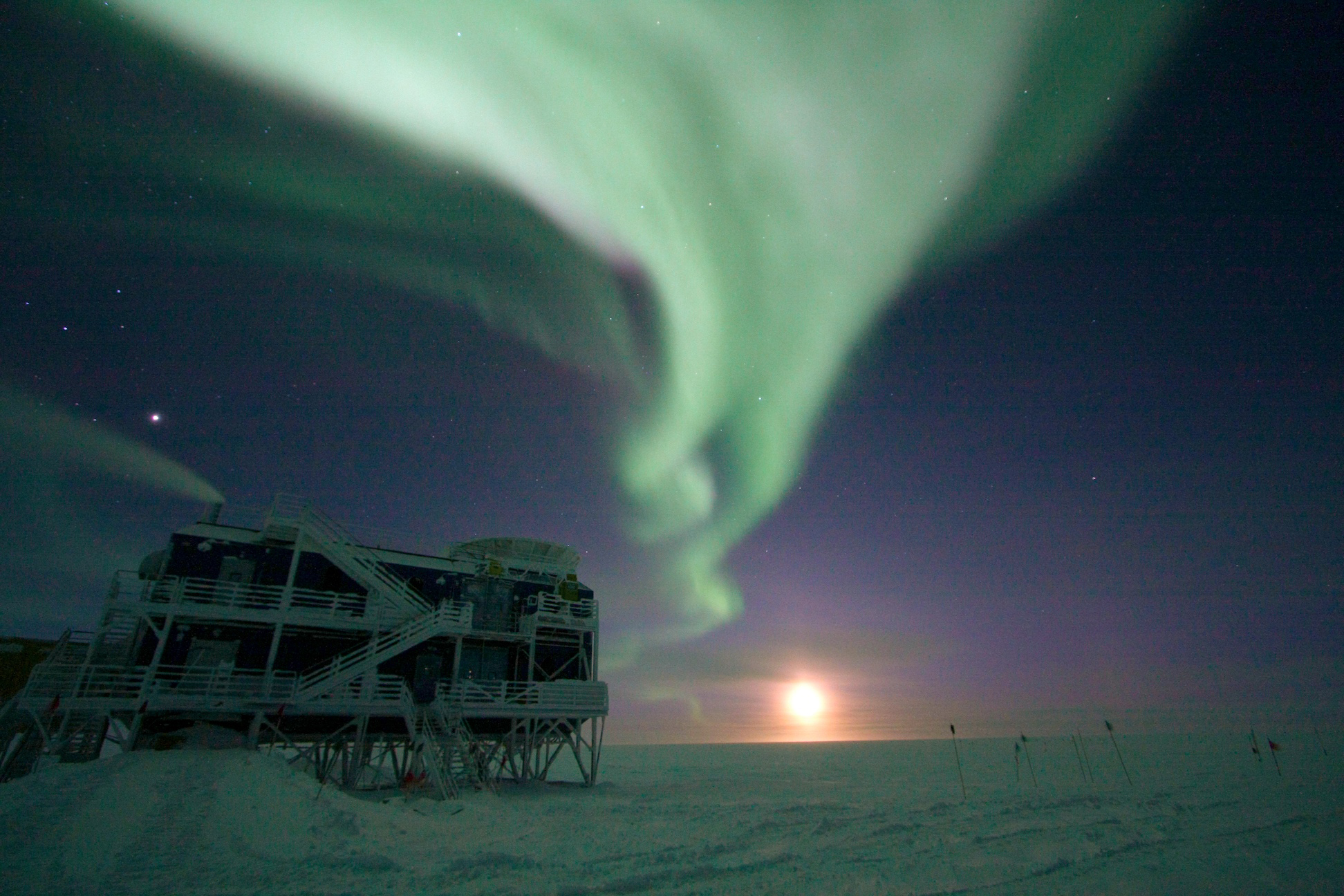 Auroras in the night sky over a science building at the U.S. research station at the geographic South Pole.