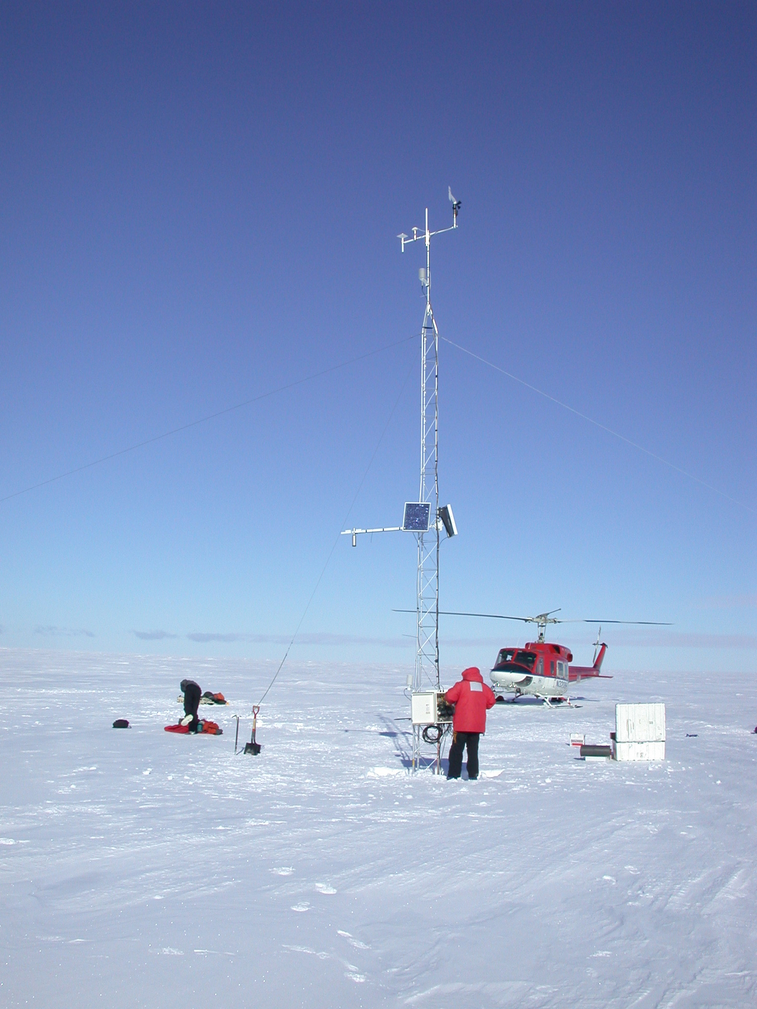 Scientific equipment and a helicopter on snow.