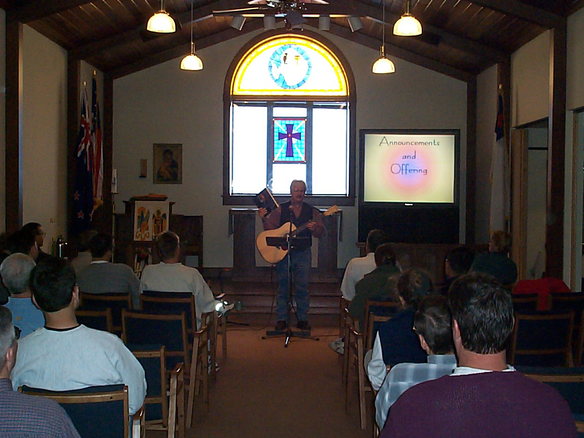 Person performs with a guitar Inside a church.