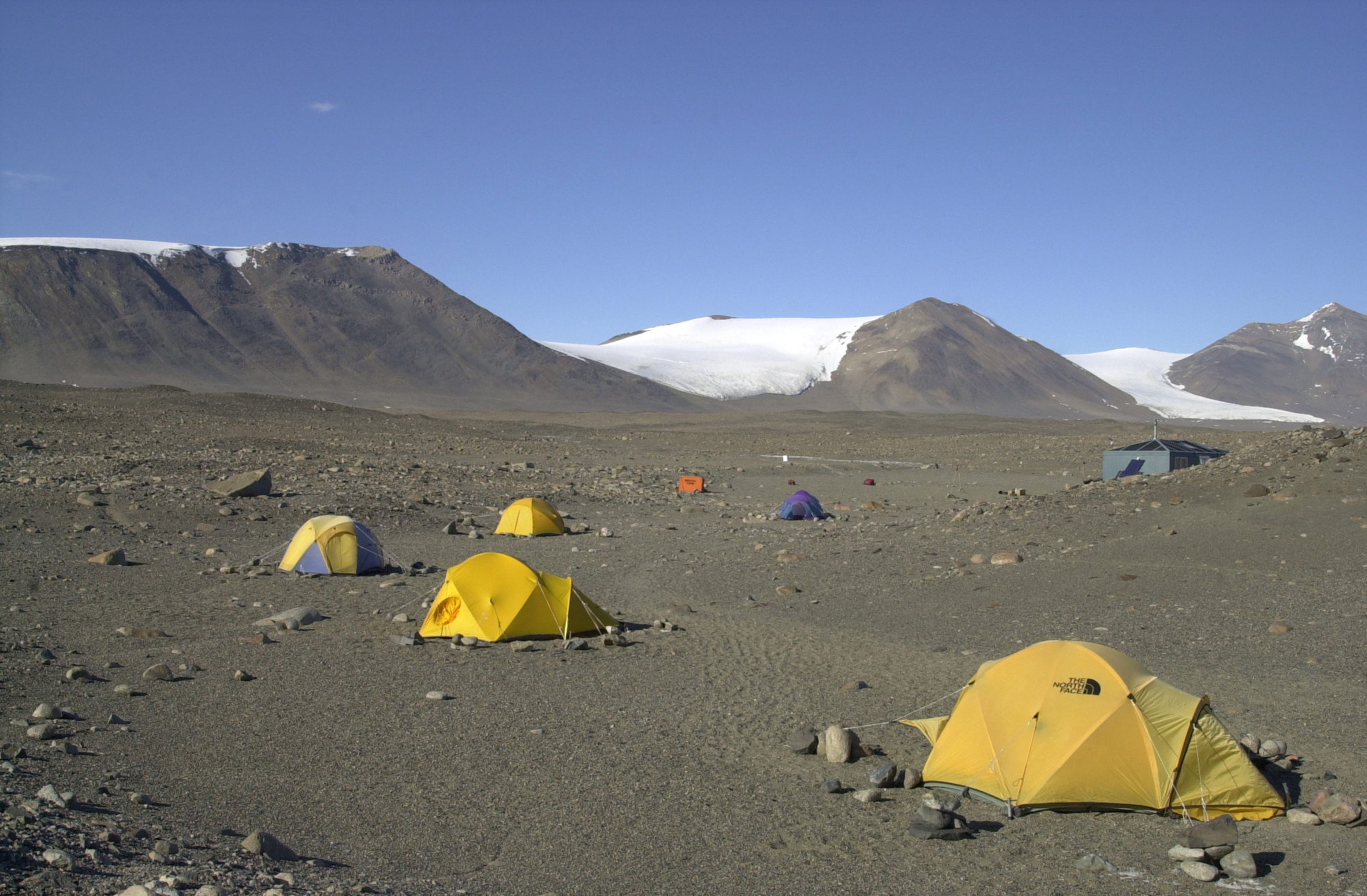 Tents sit on dry, rocky ground.