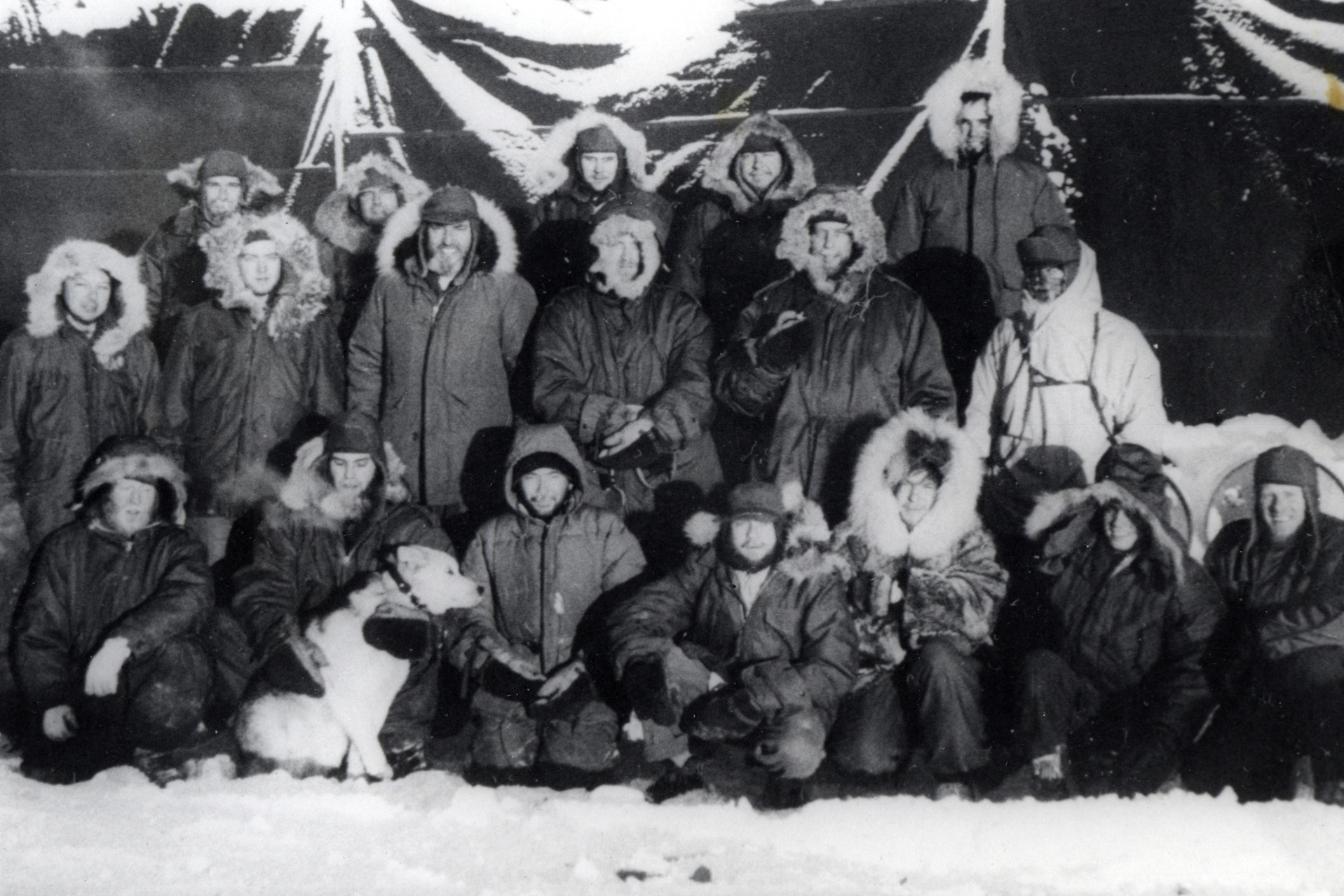 A group of men pose for a picture in winter clothes.
