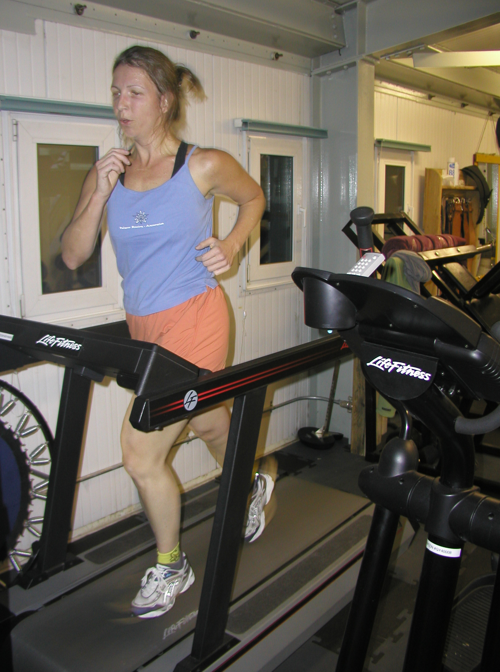 Woman runs on treadmill.