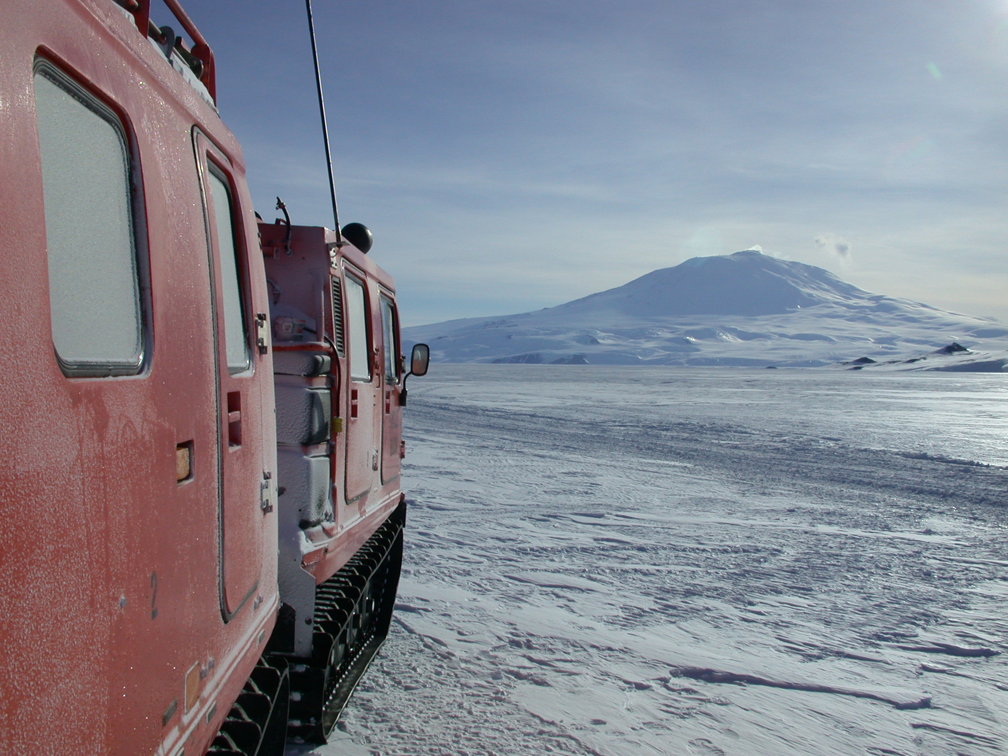 A tracked vehicle with a volcano in the background.