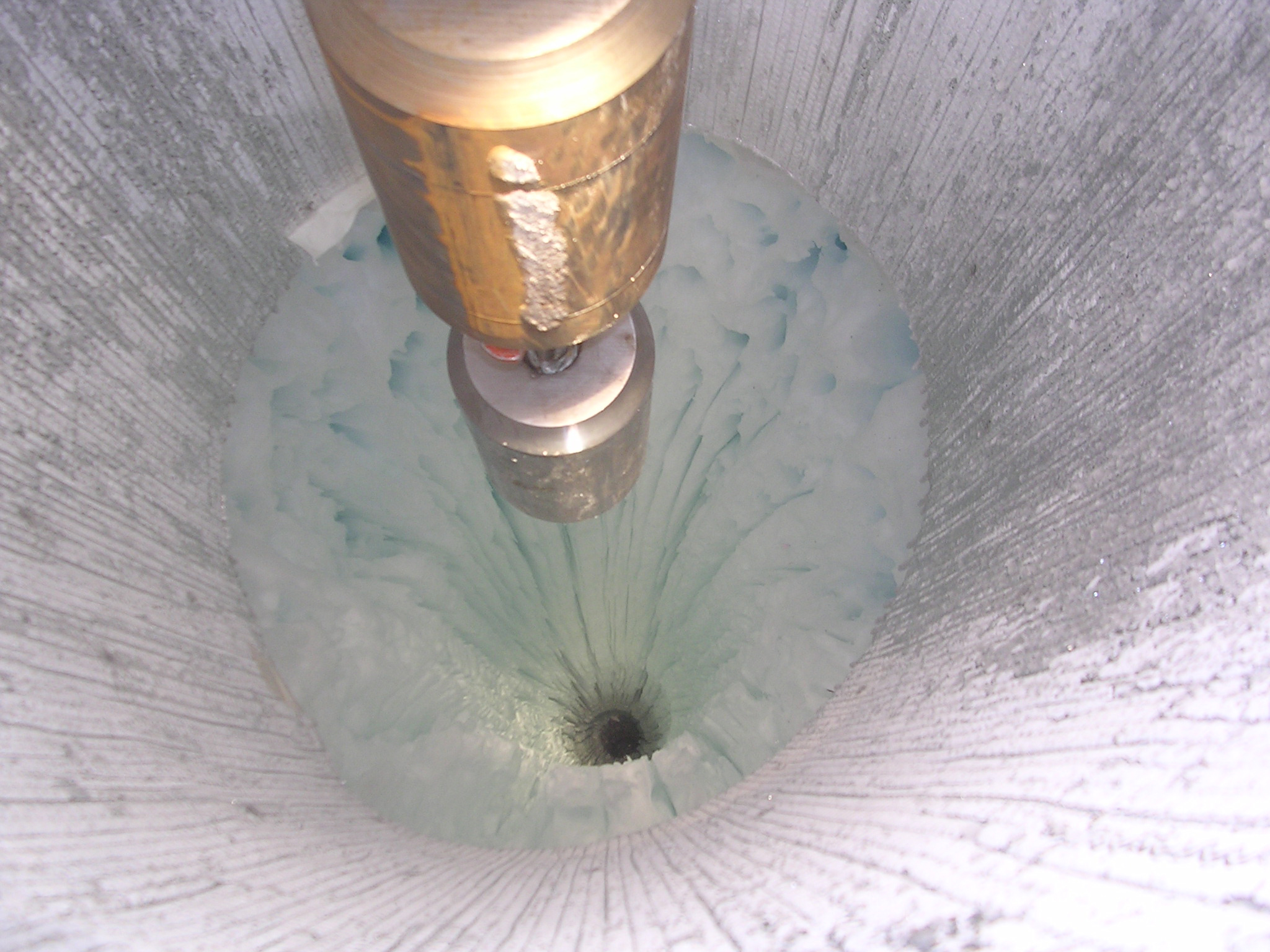 An instrument drills a hole in ice.