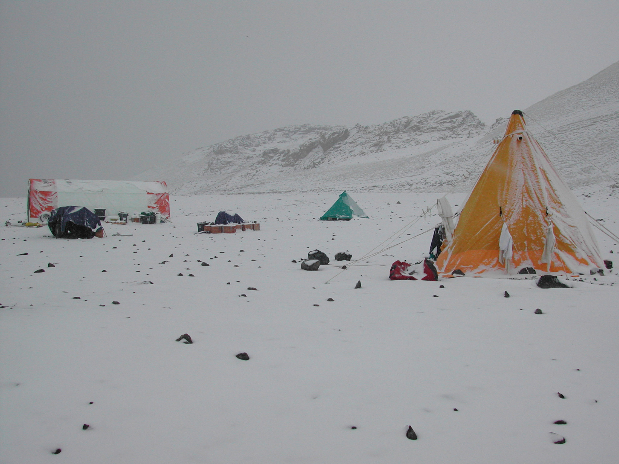 Snow covers a field camp.