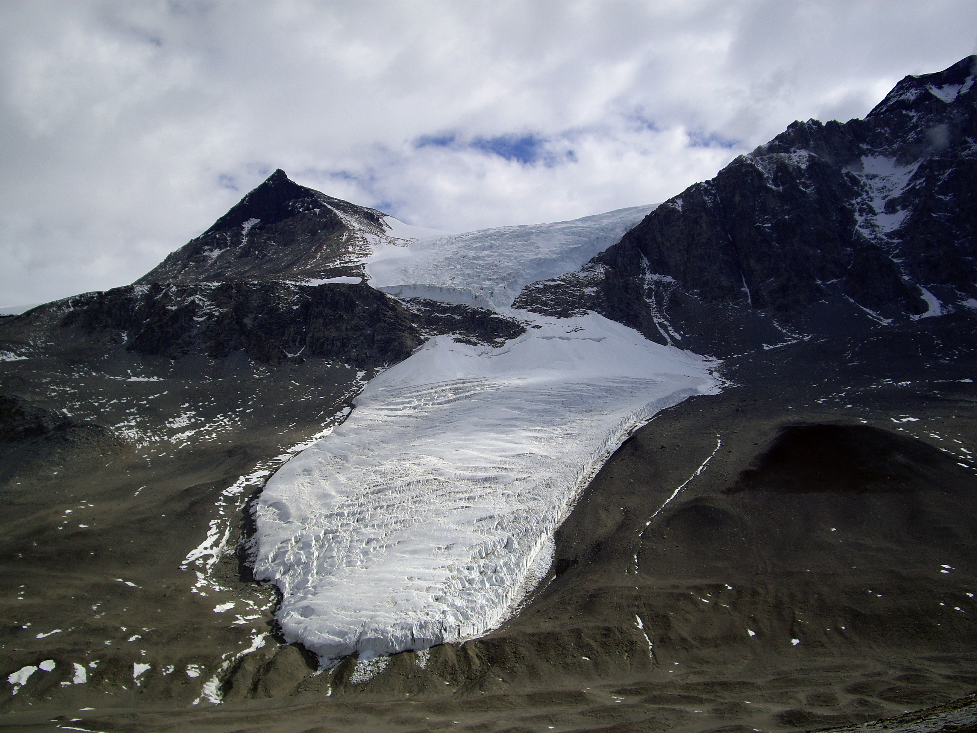 A glacier flowing down a mountainside.
