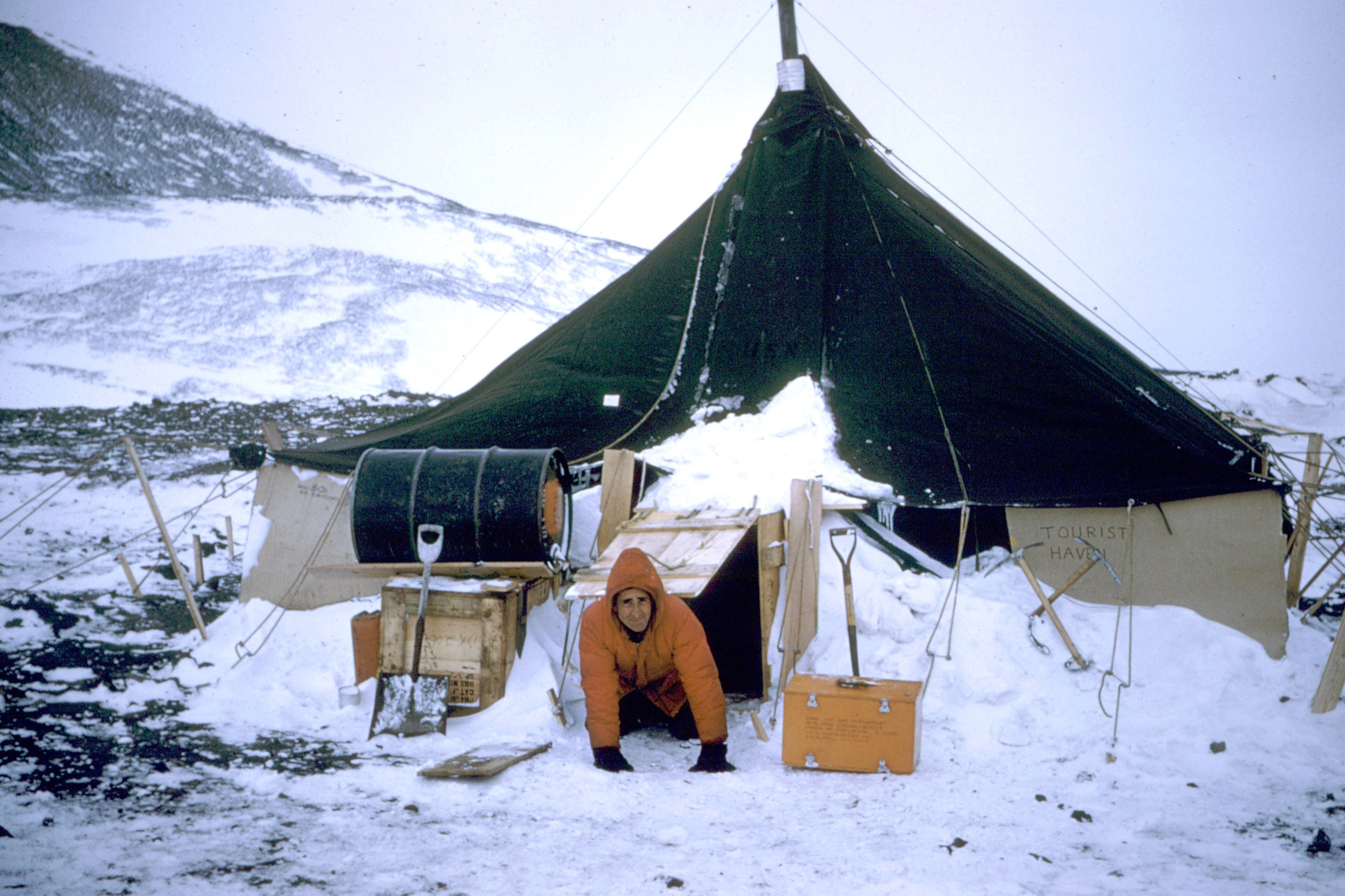 A man crawls out of a tent