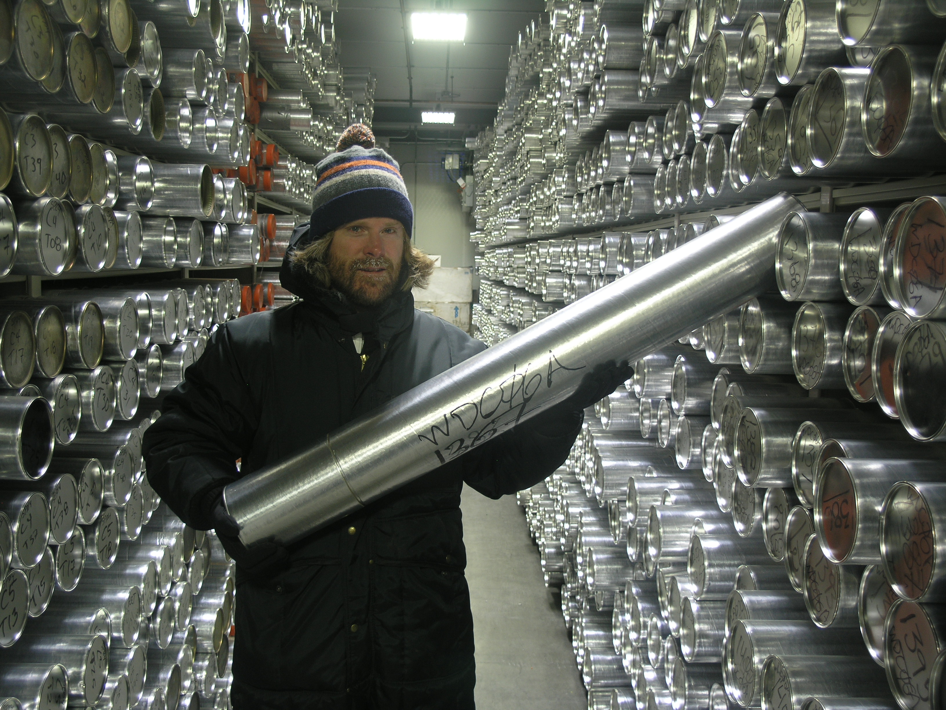 A man holds a long silver tube.
