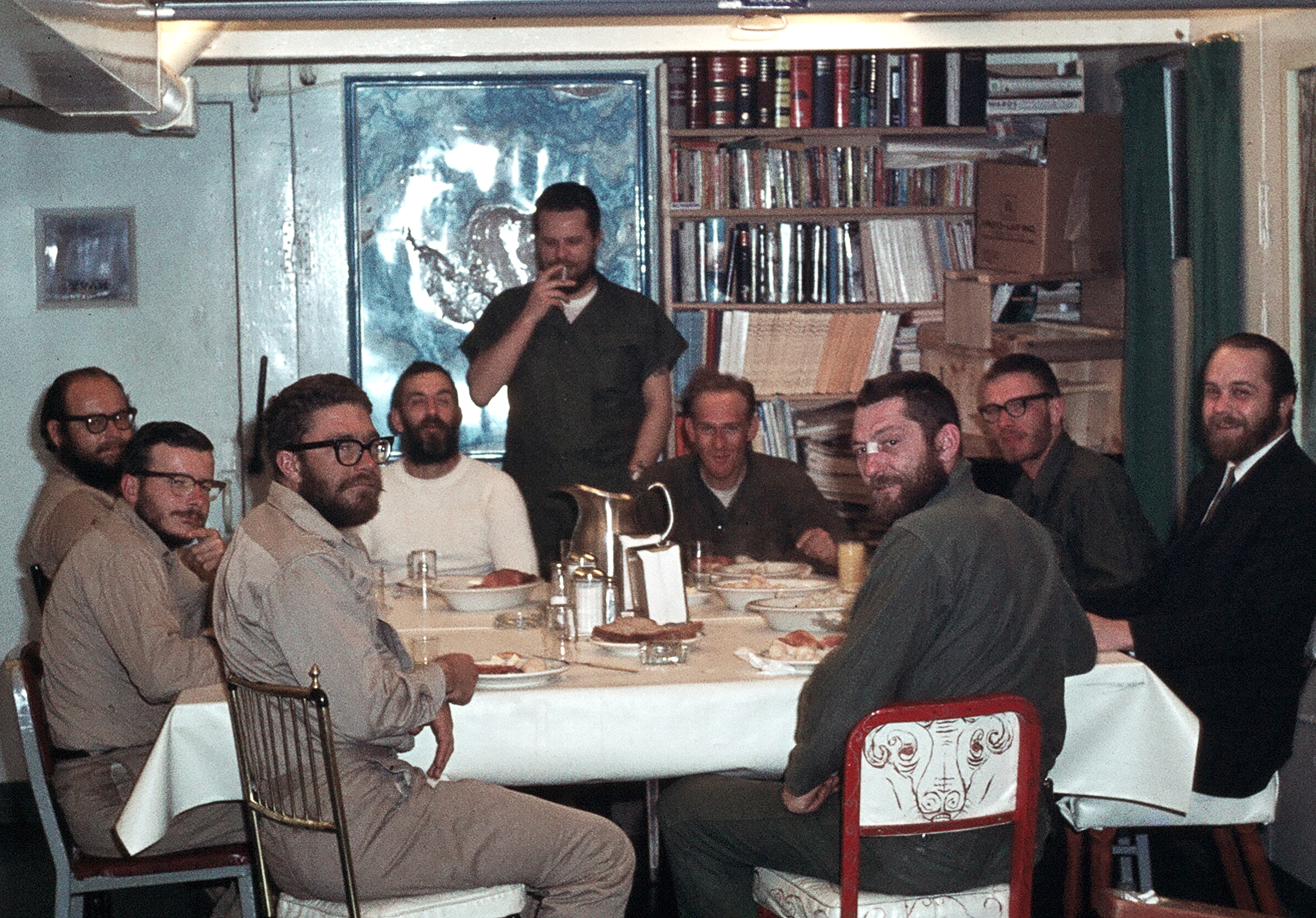 Men sit down at a table for a meal.