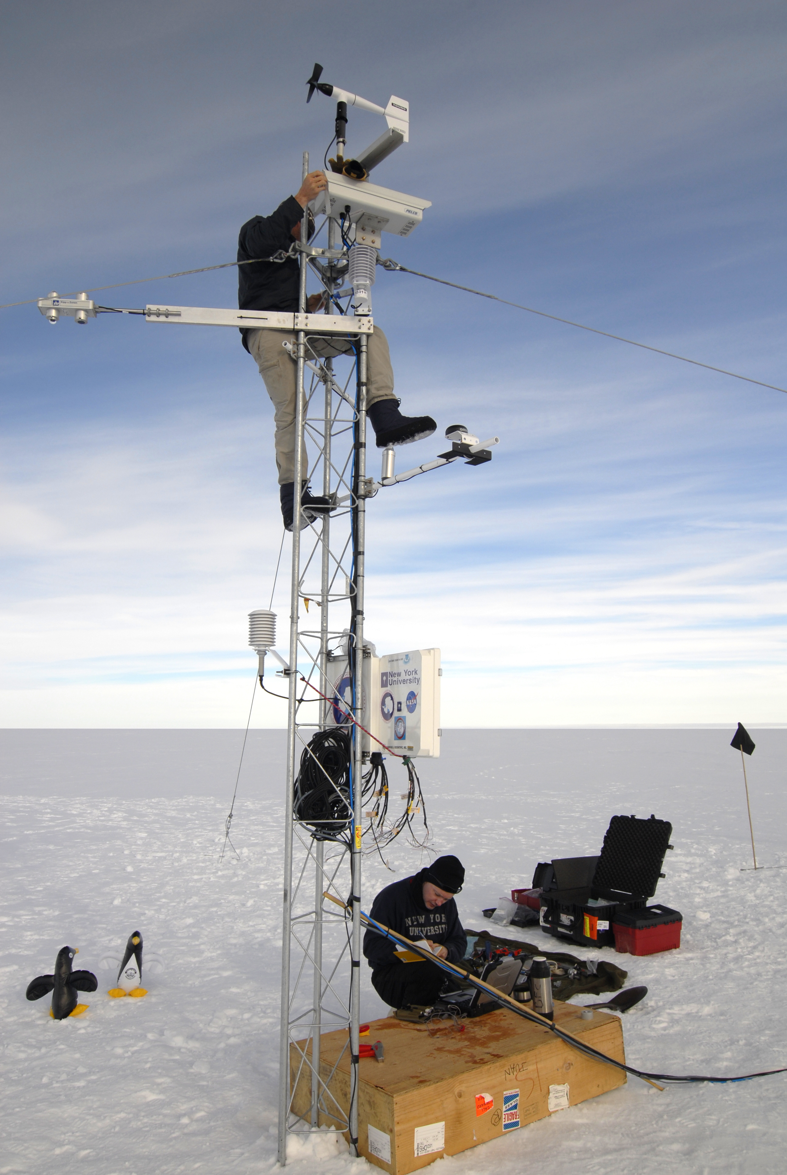 People erect an antenna with instruments.