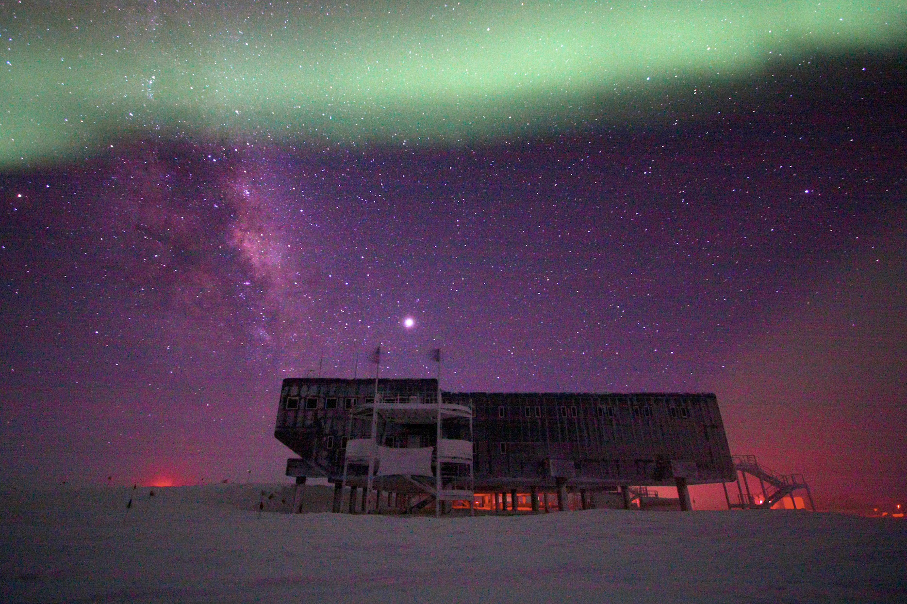 An aurora appears over a building at the South Pole.