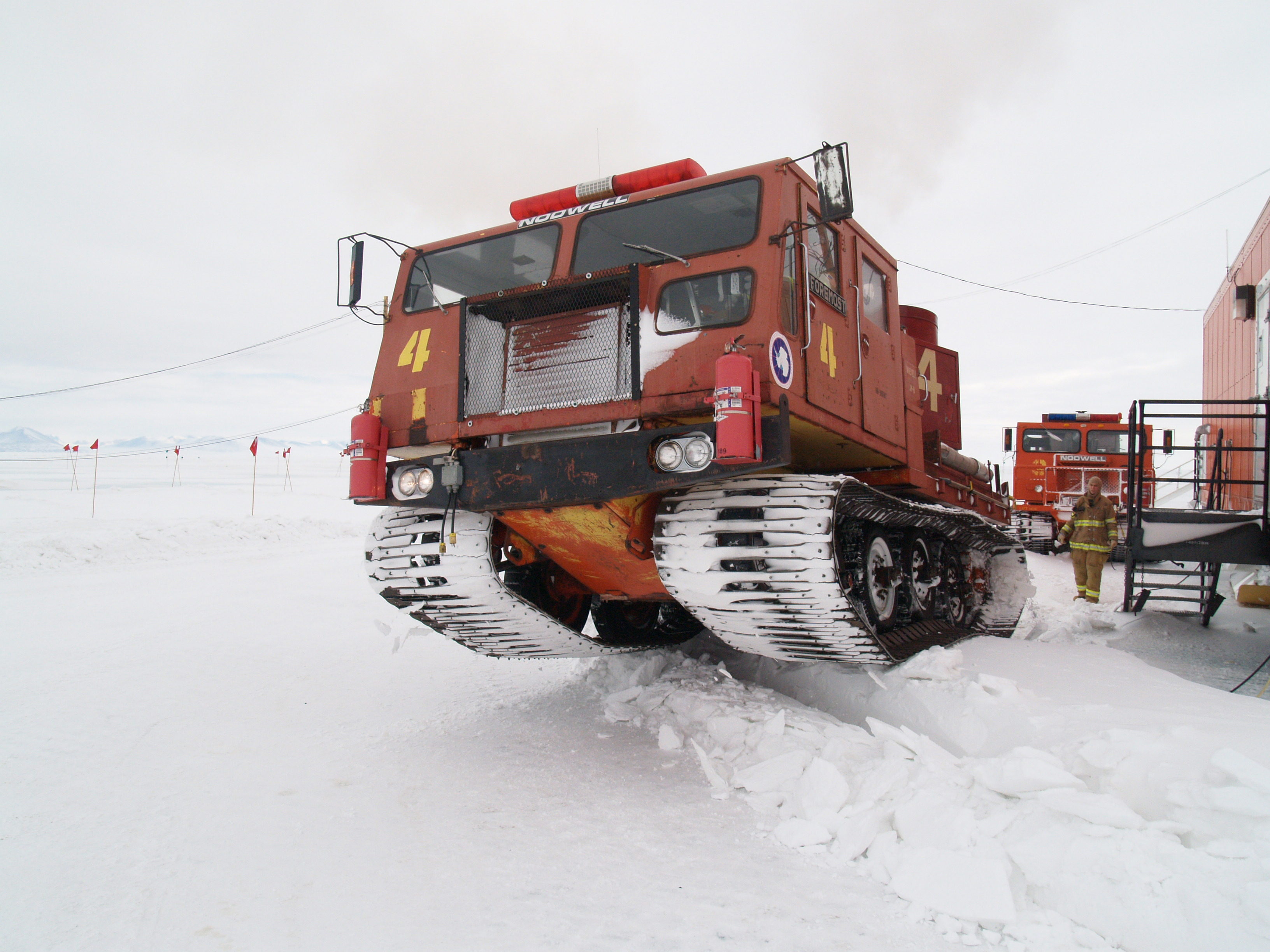 A fire engine tractor on snow.