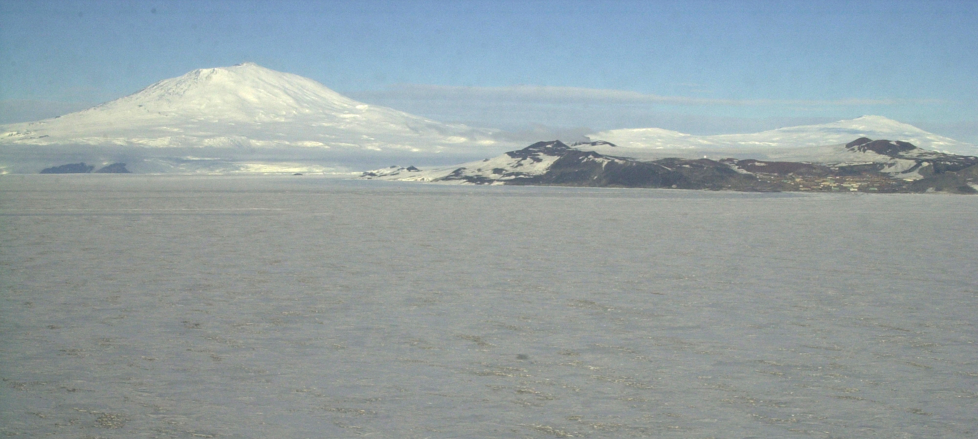Aerial of ice below and mountain in distance.
