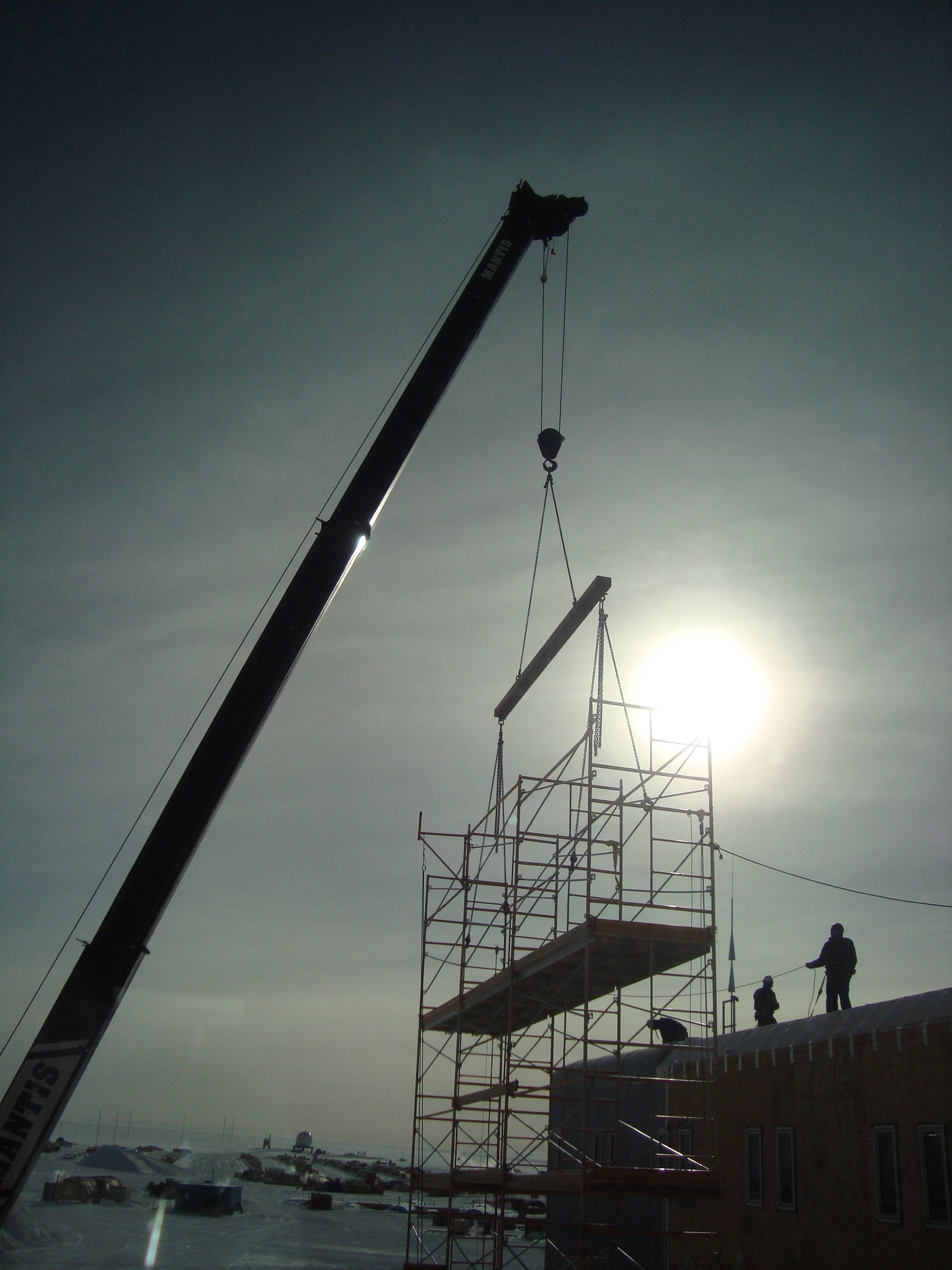 A construction crane holds scaffolding.