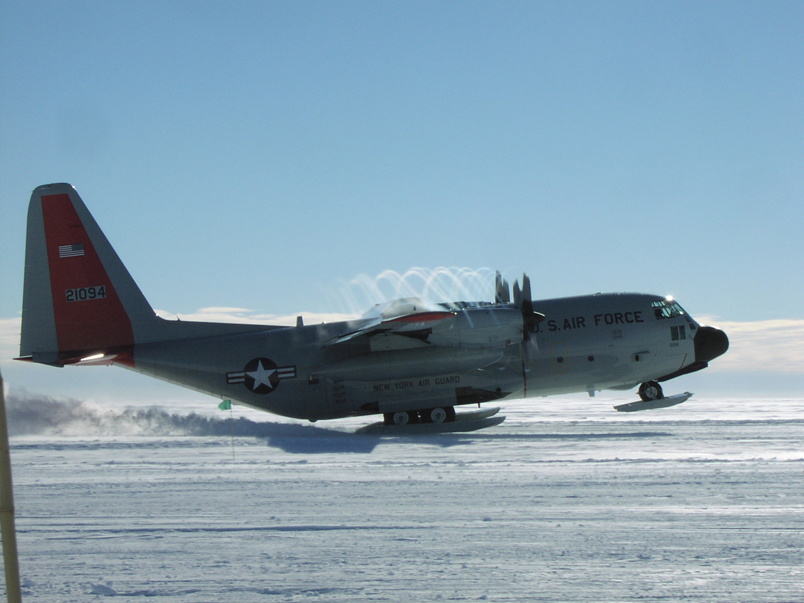 A ski-equipped airplane takes off from a snow covered surface.
