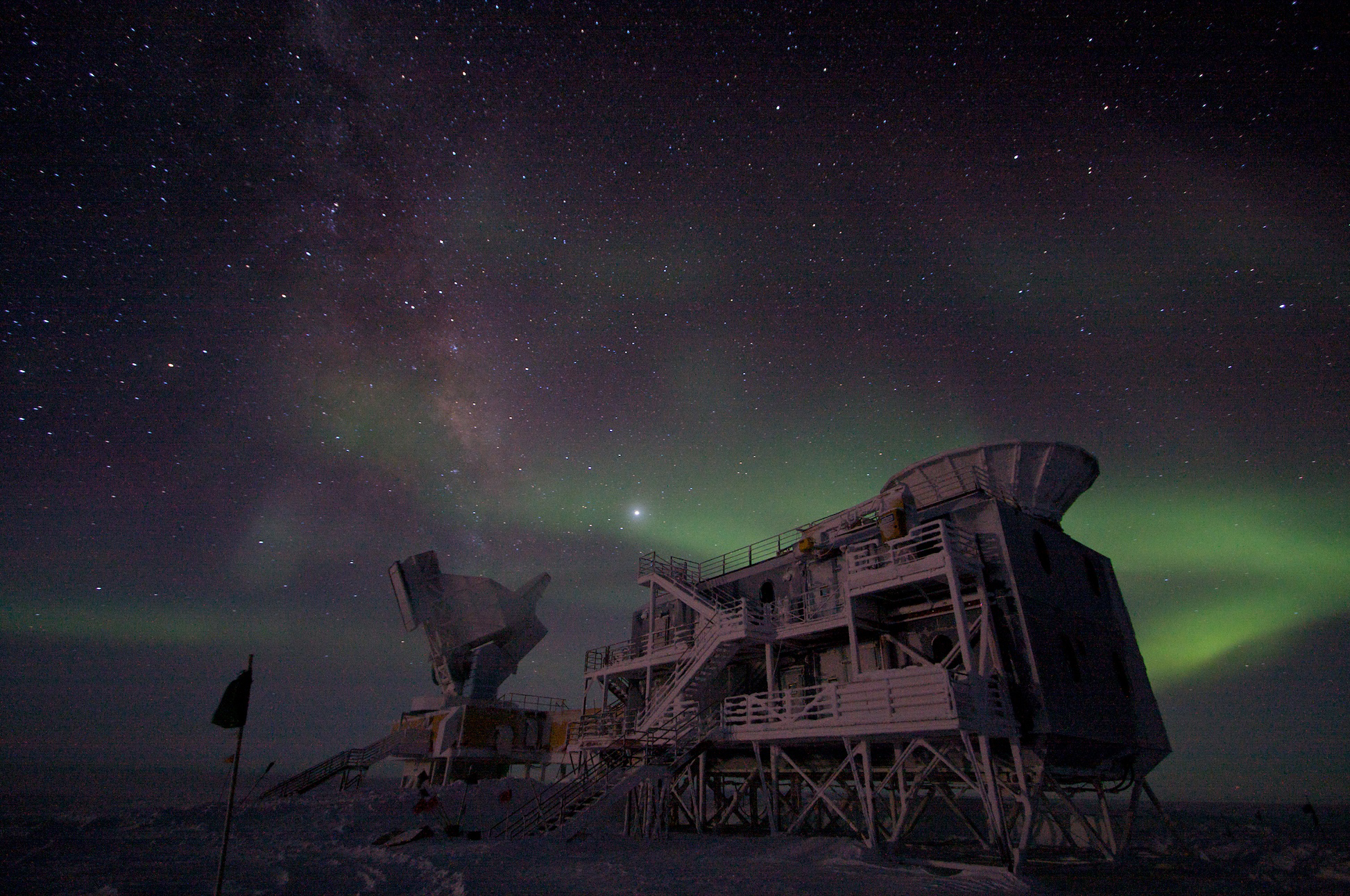 Aurora and night sky offer dramatic backdrop to science buildings at the South Pole.