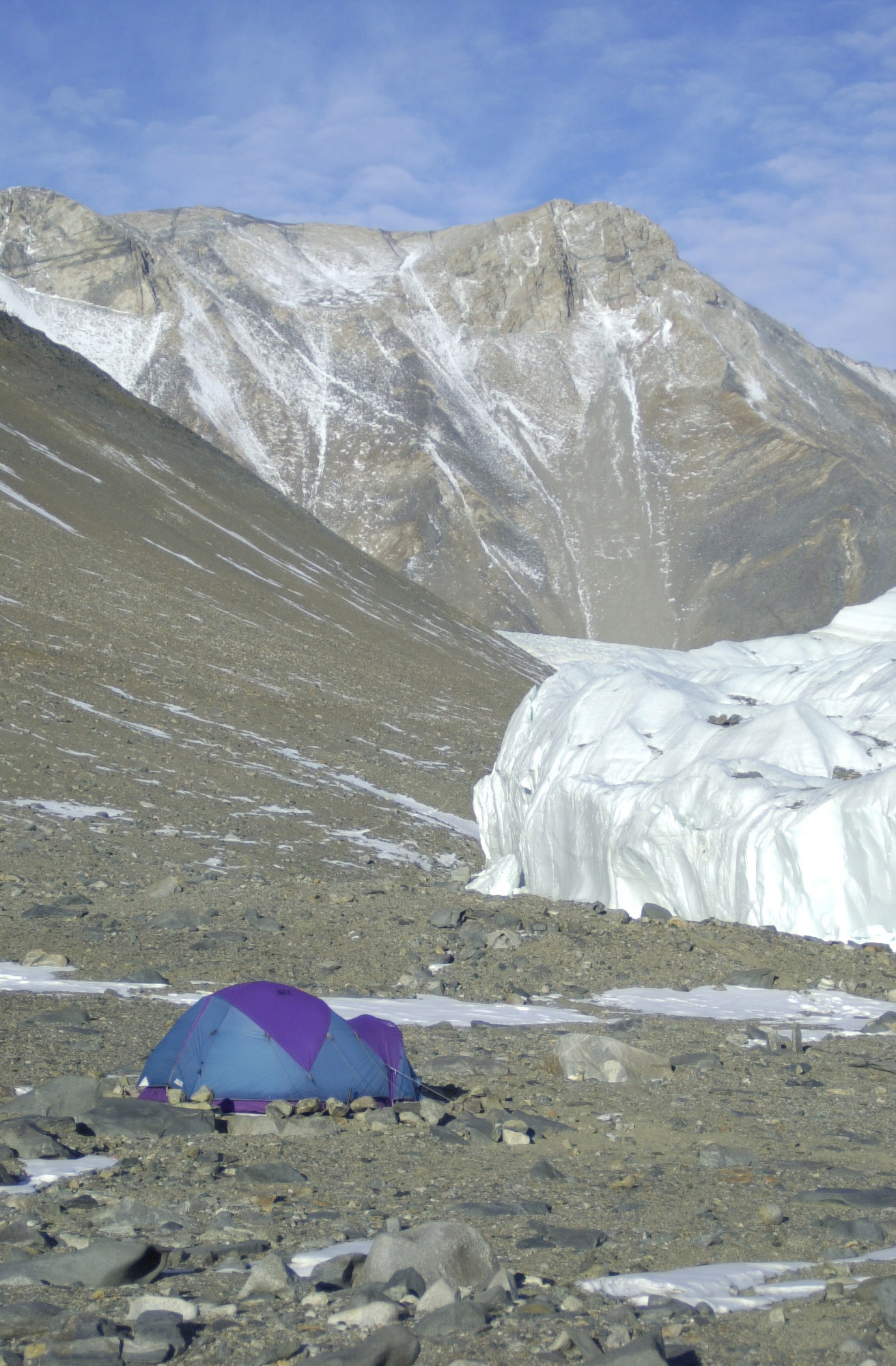 A tent sits near a glacier.
