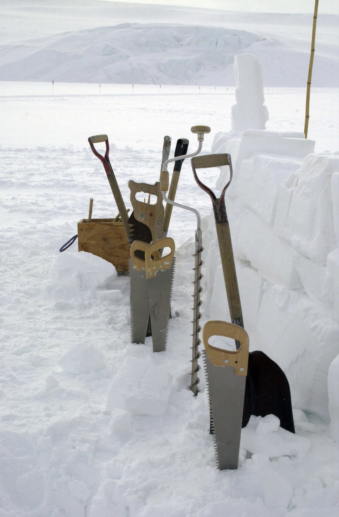 Saws, drills and shovels in the snow.