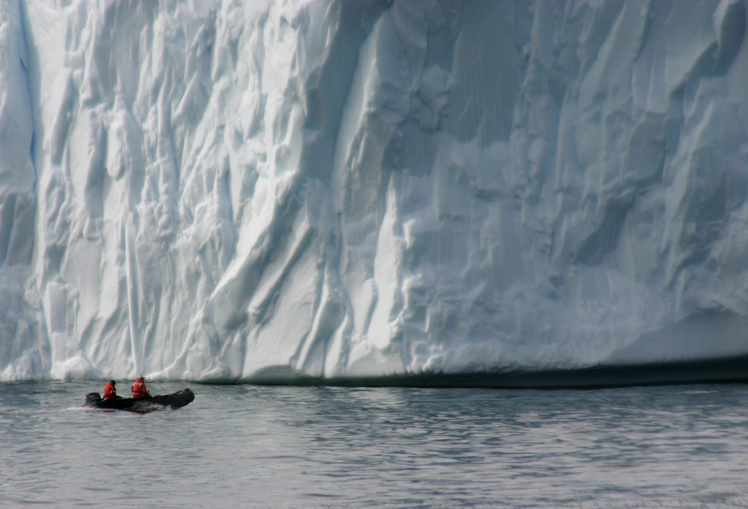 Inflatable boat near iceberg.