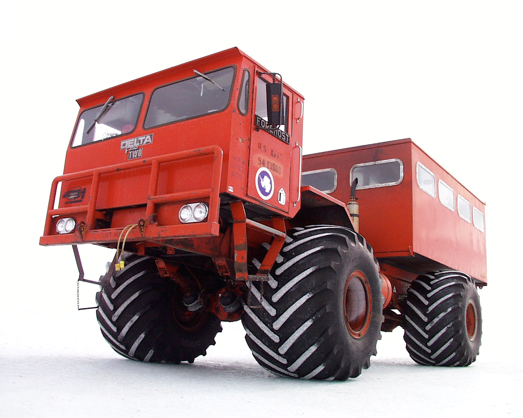 An enormous red truck with tires nearly six foot tall.