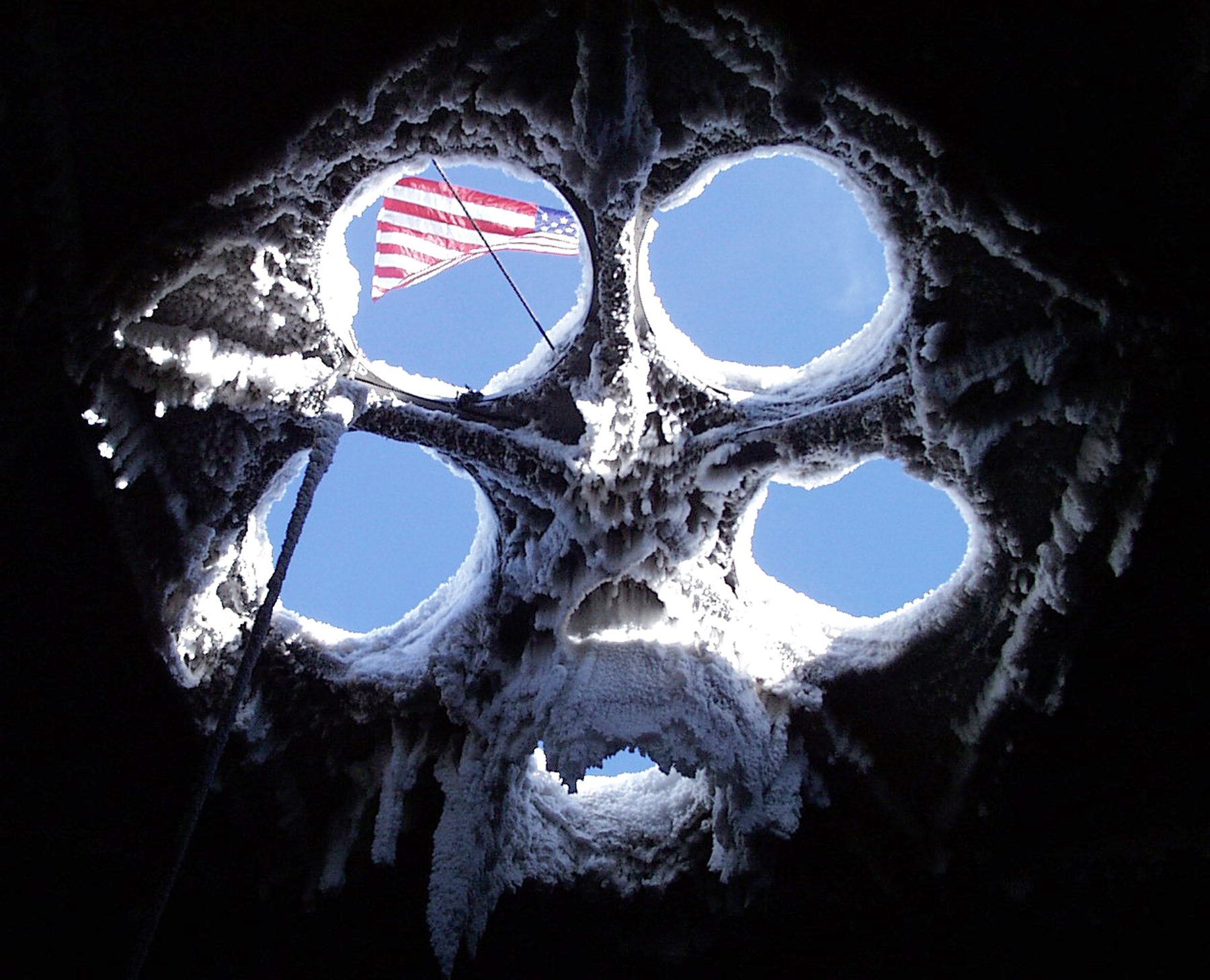 The U.S. flag can be seen through ventilation holes in the ceiling of an icy dome. 