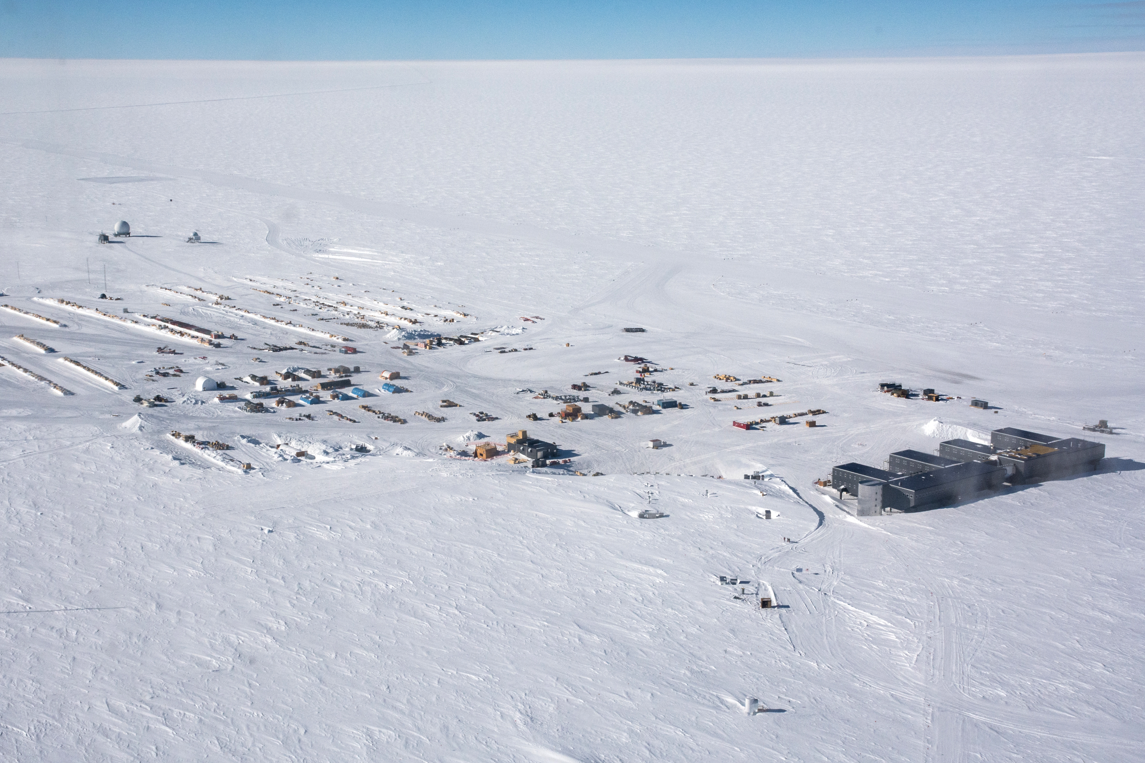 Aerial photos of buildings on a flat white snow surface.