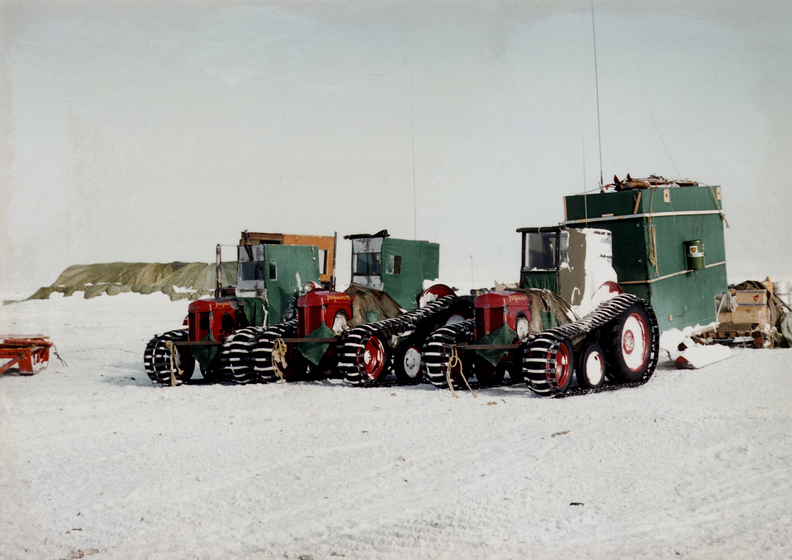 Three Massey Ferguson tractors parked on snowy terrain.