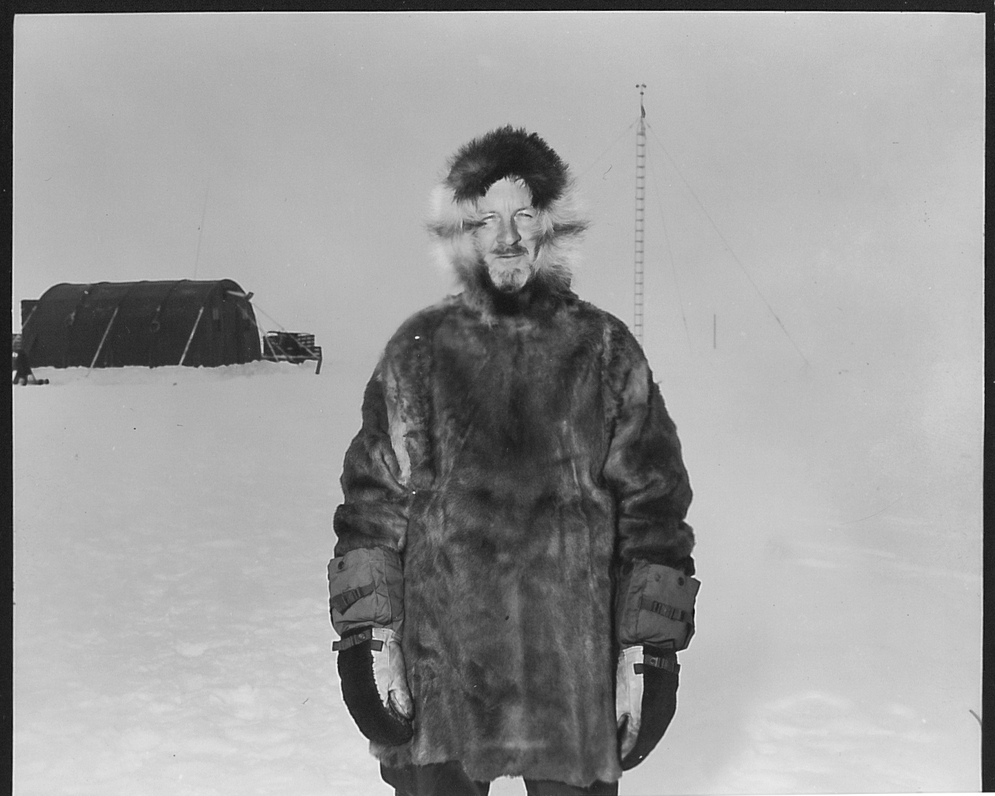 A man in a fur coat outside in a snowy landscape.