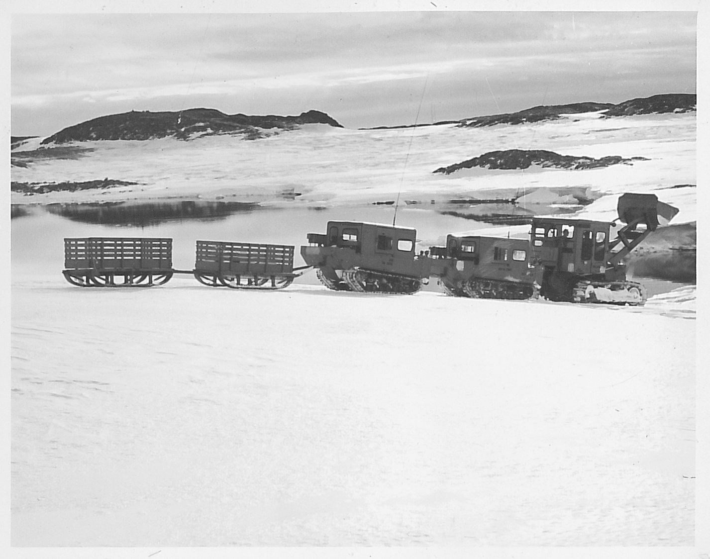 Tractors pulling sleds across the snow.