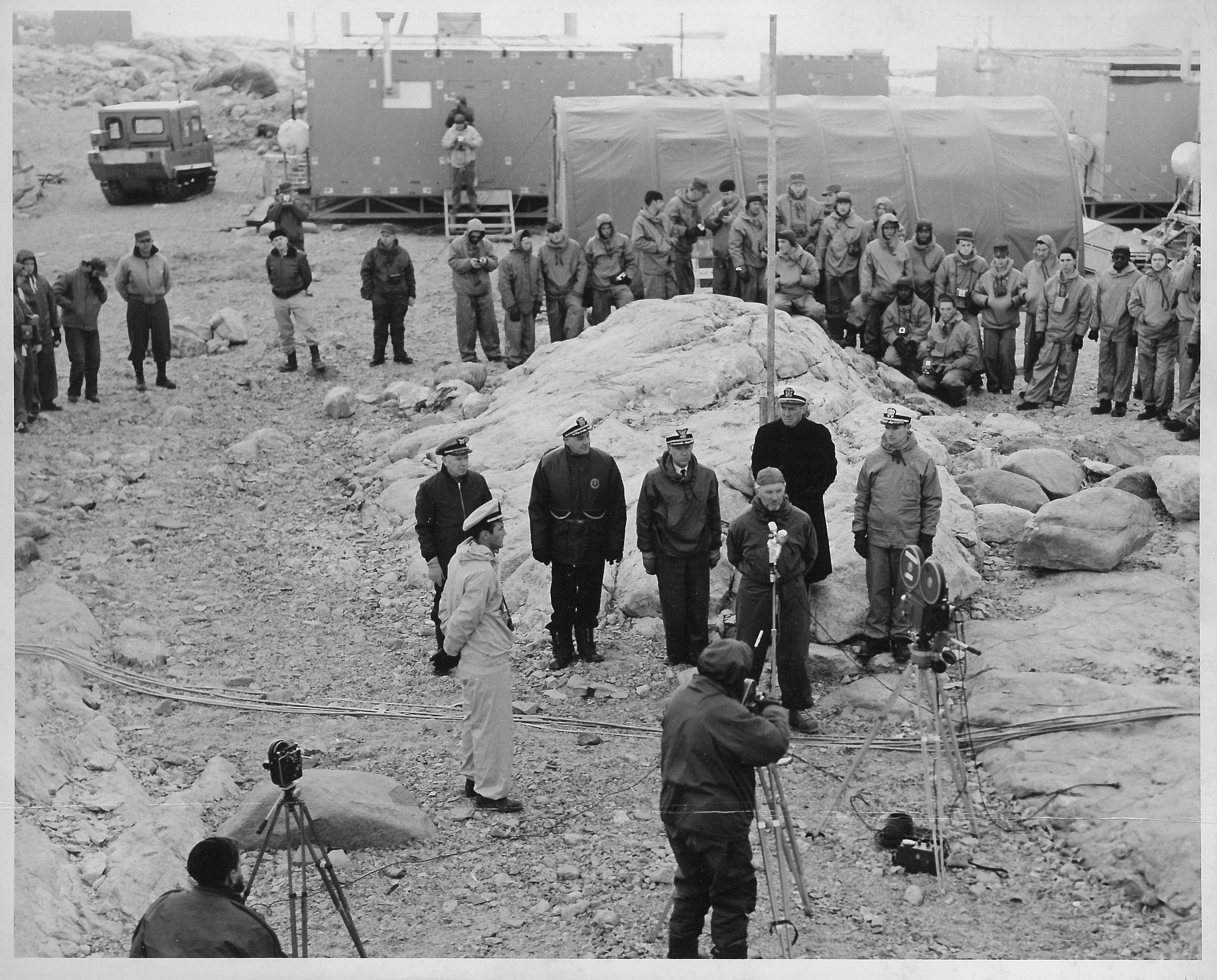 A group of men standing around a flagpole.