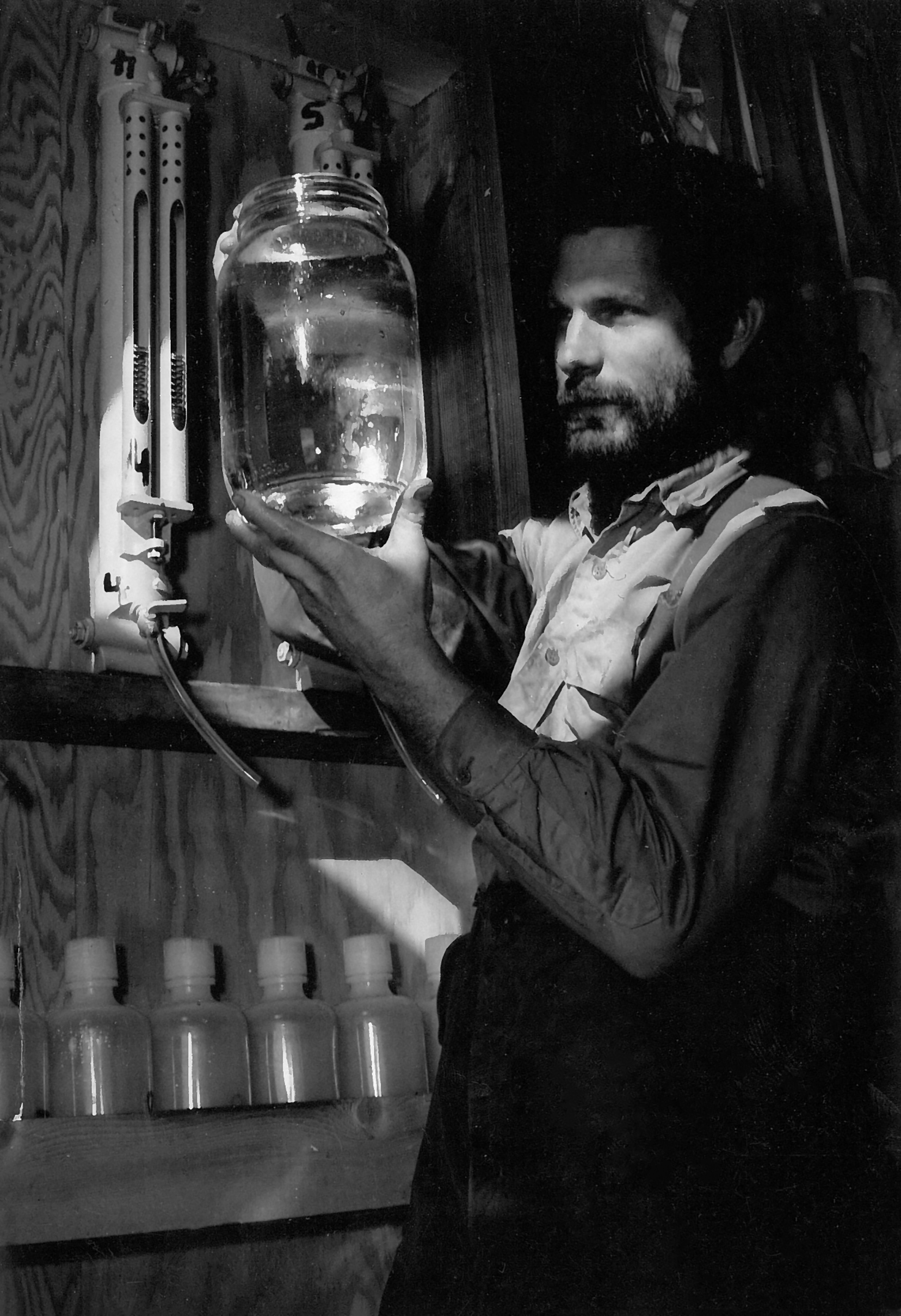 1960 photo of a scientist holding a jar.
