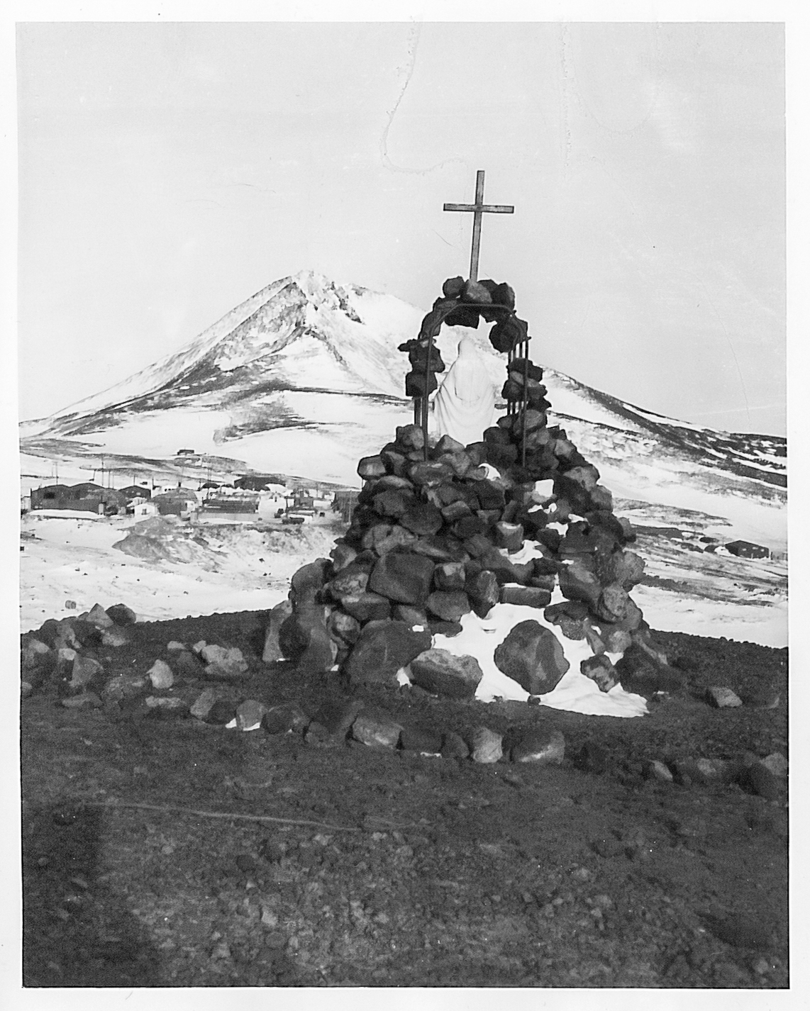 A shrine built with rocks and a cross on top.