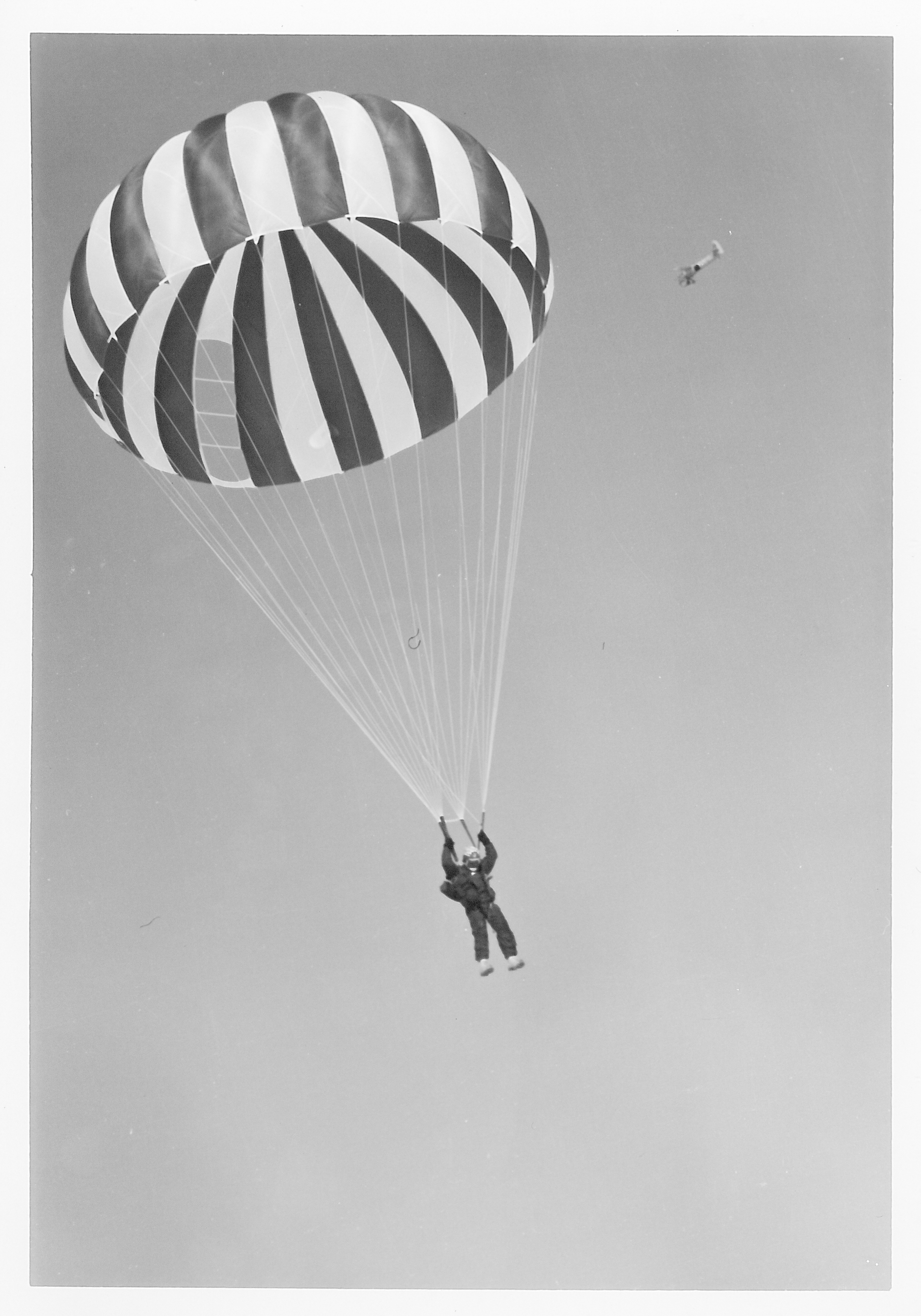 A man falling to the ground with a parachute.