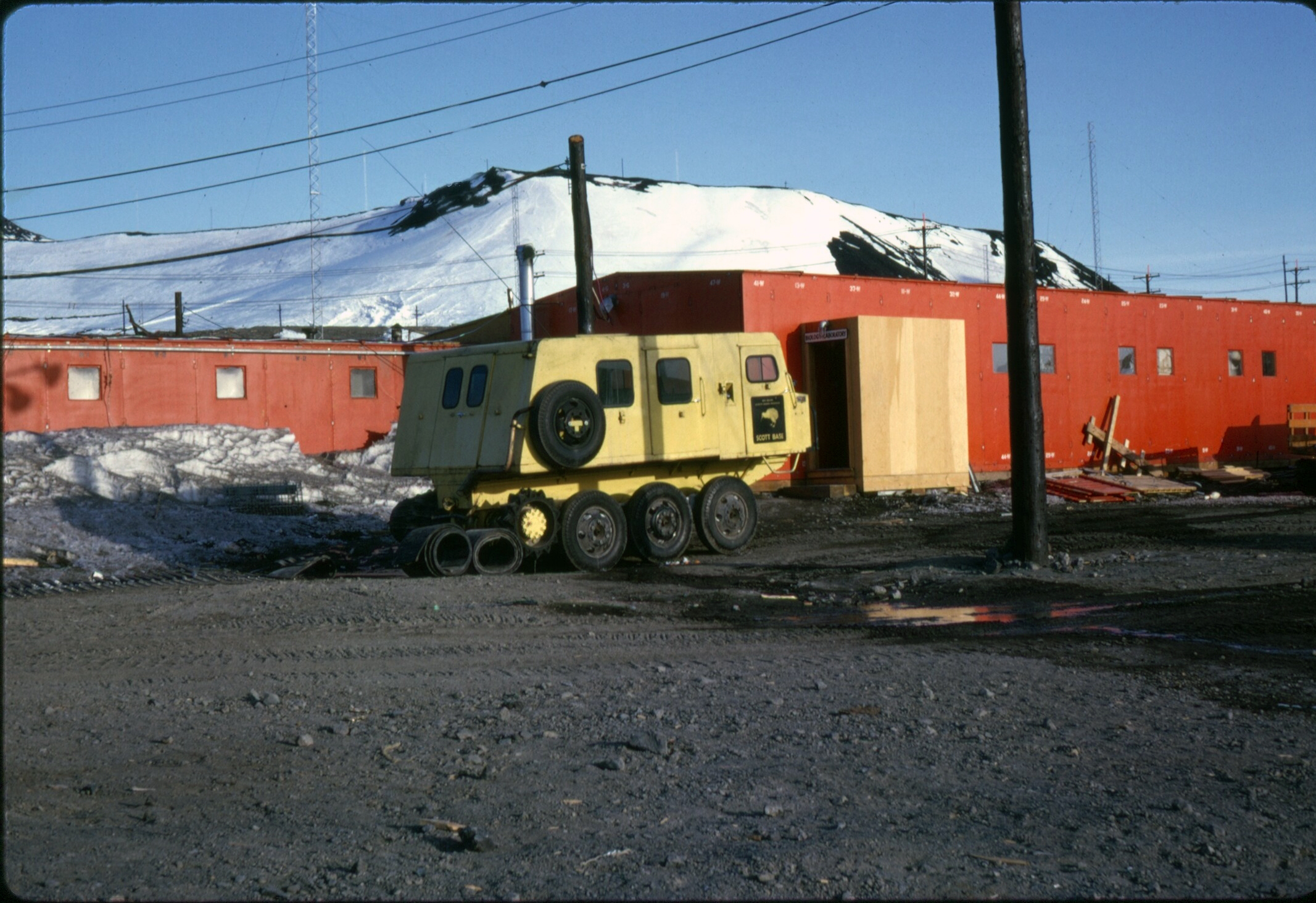 Orange buildings with a vehicle parked by them.