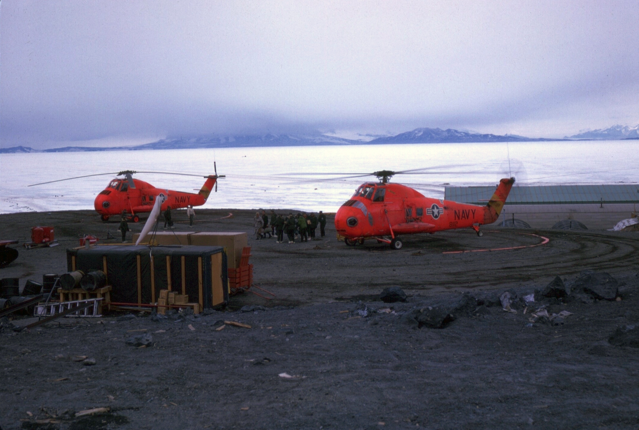 Helicopters on a gravel surface.