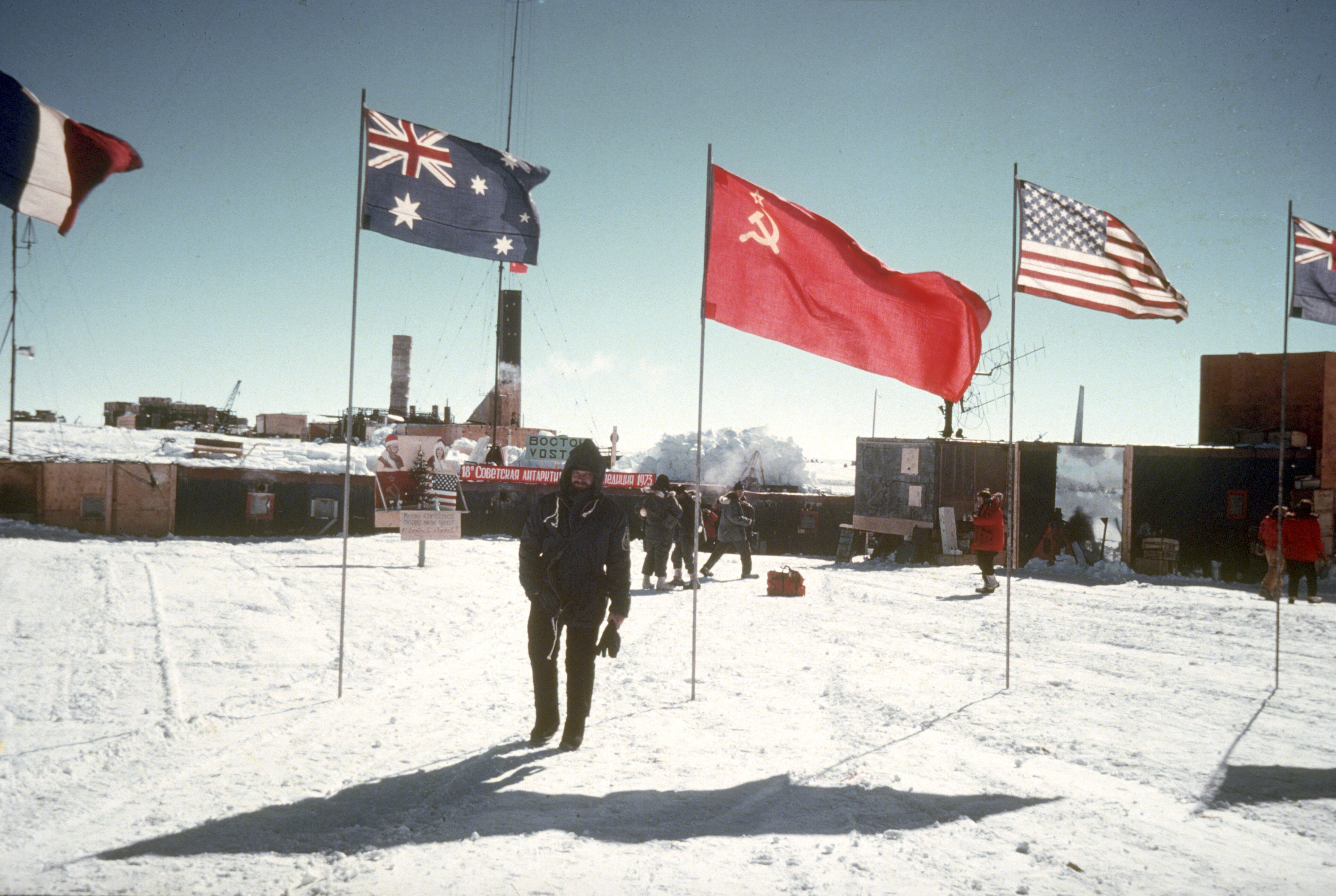 A man stands by national flags.