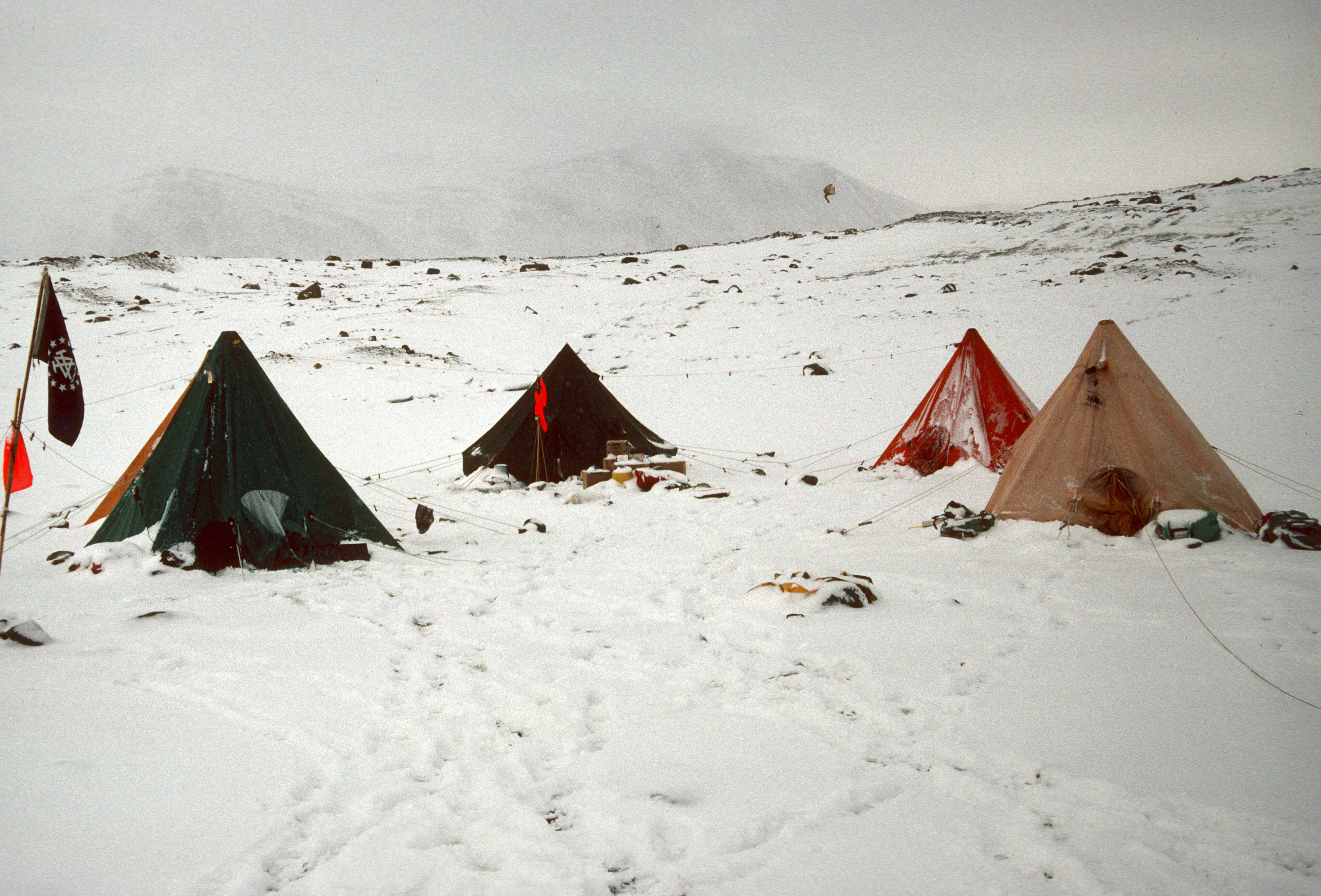 Four tents on a snow-covered landscape.