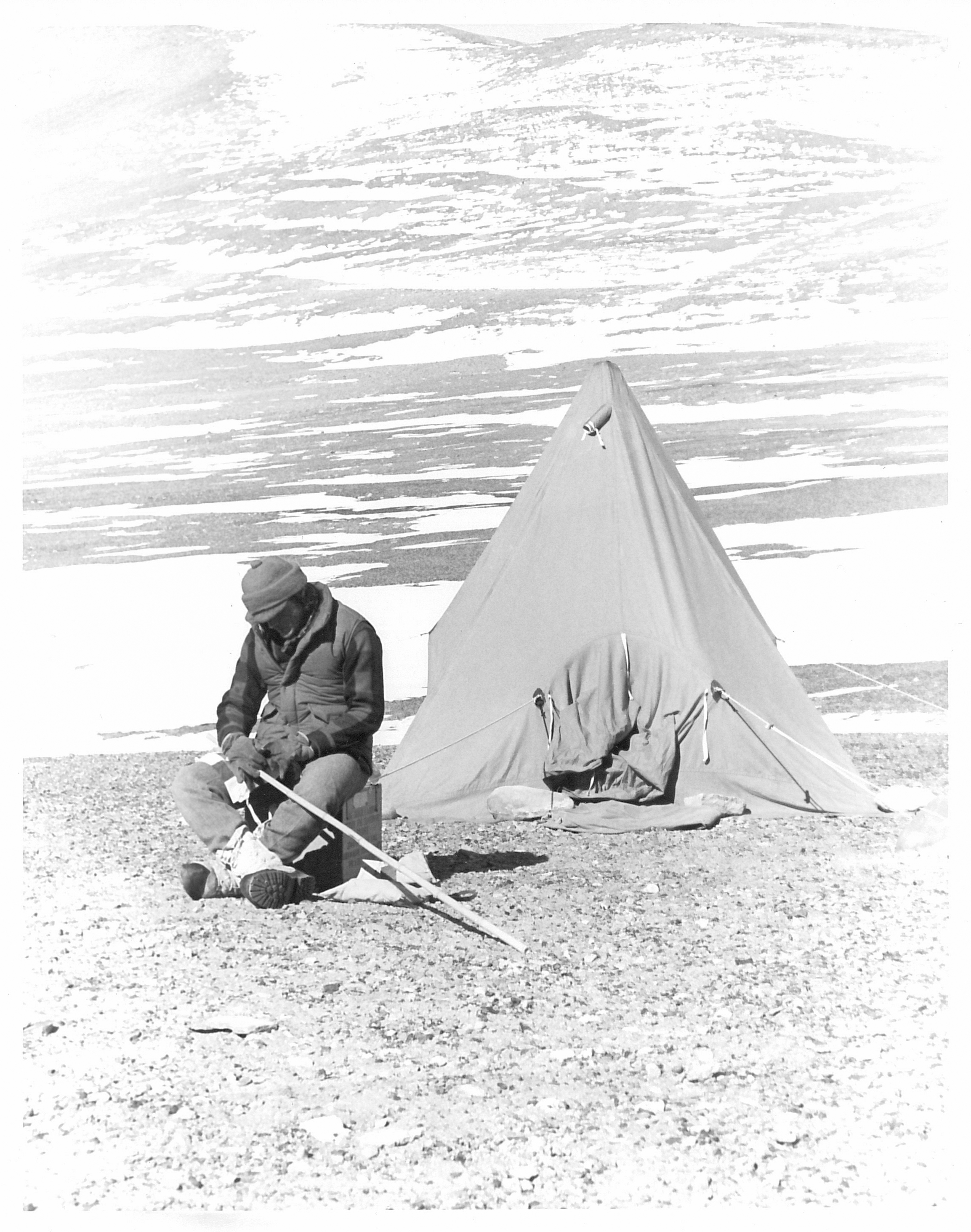 A man sitting in front of a tent.