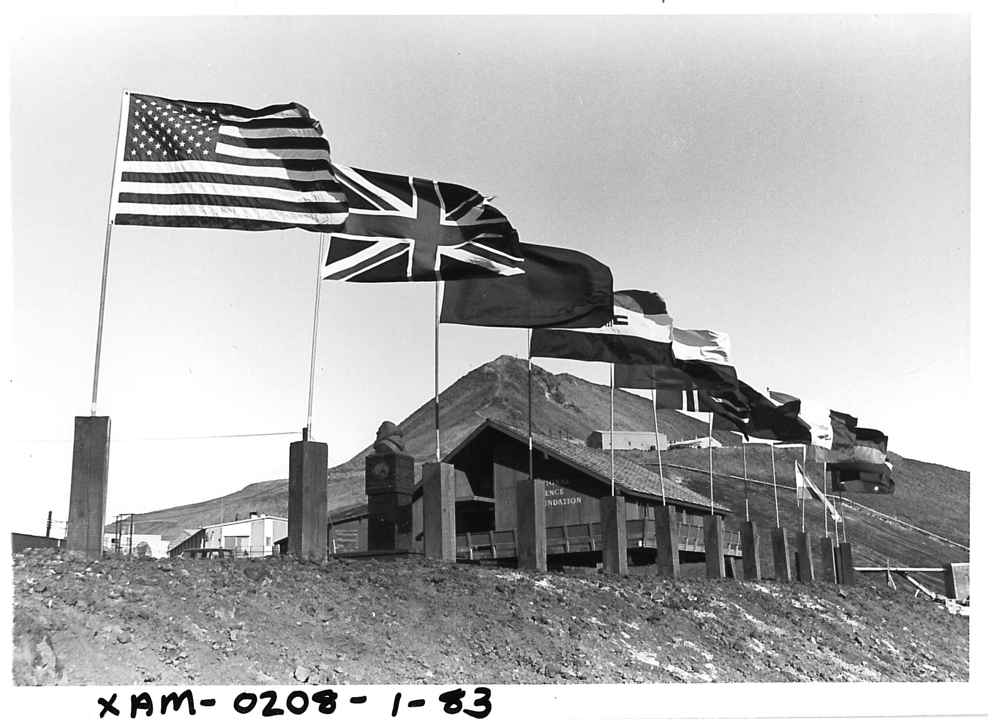 Flags from different countries lined up on a hilltop.