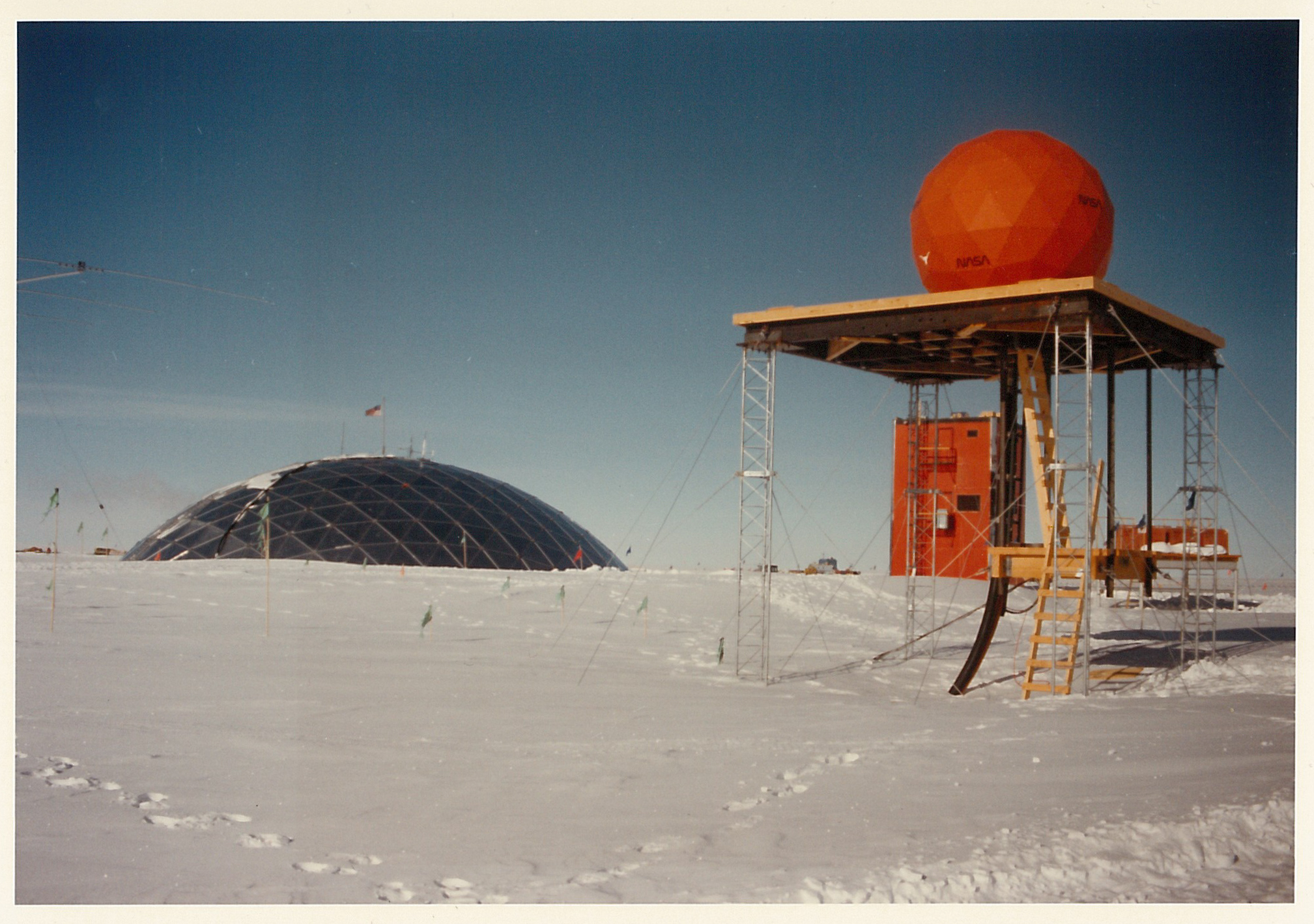 A sphere on a platform on the snow and a dome in the background.