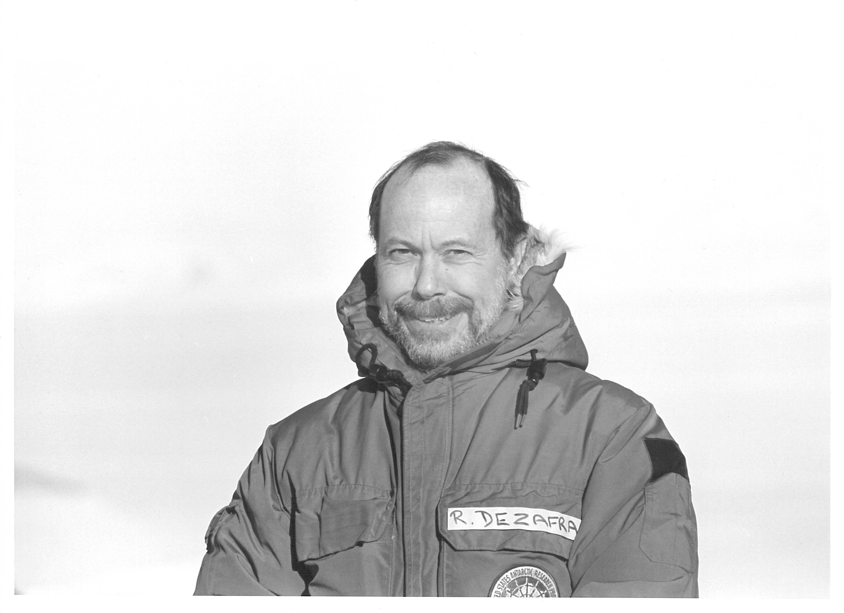 A portrait of a man in a parka outside.