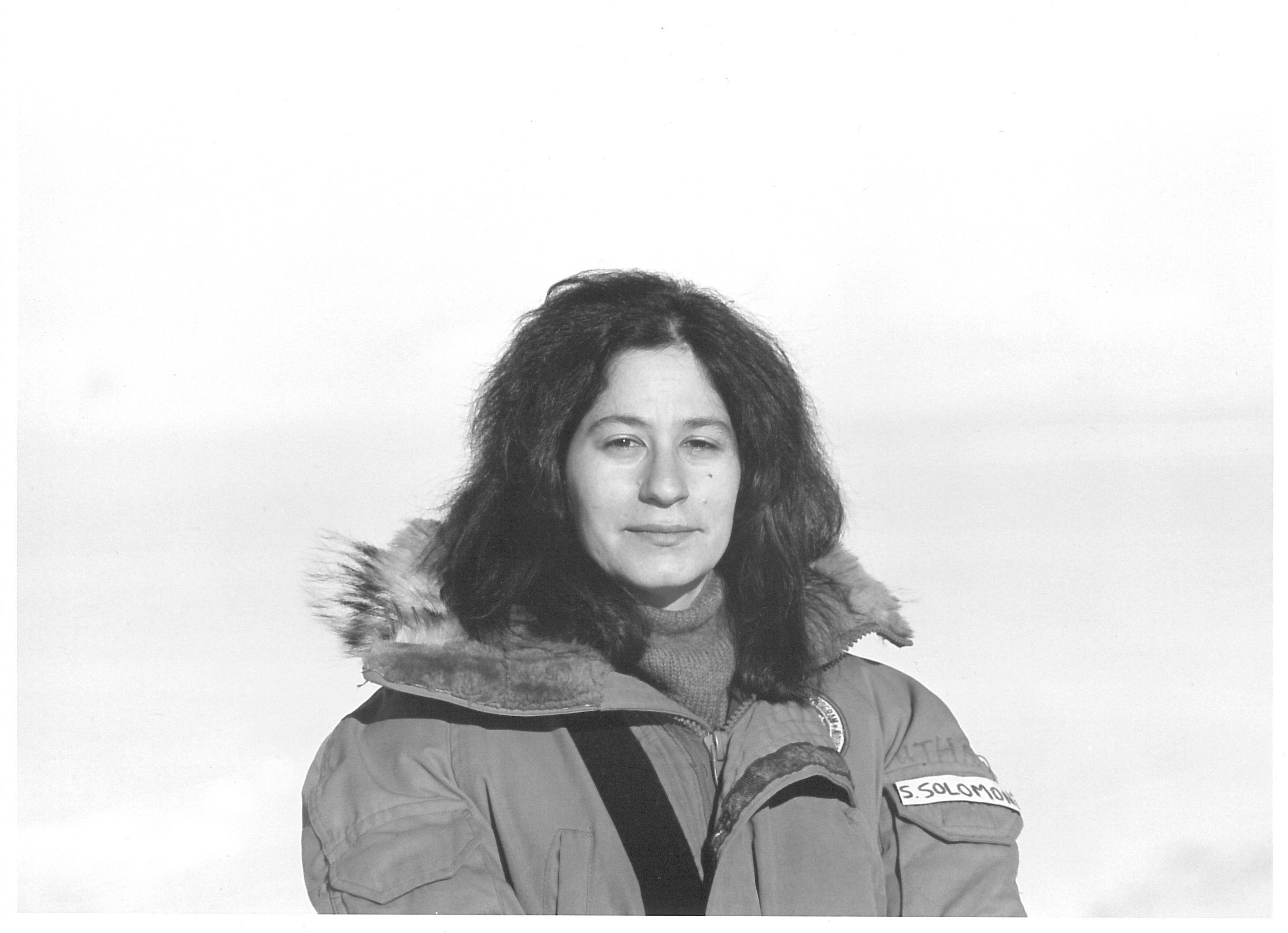 A portrait of a woman in a parka outdoors.