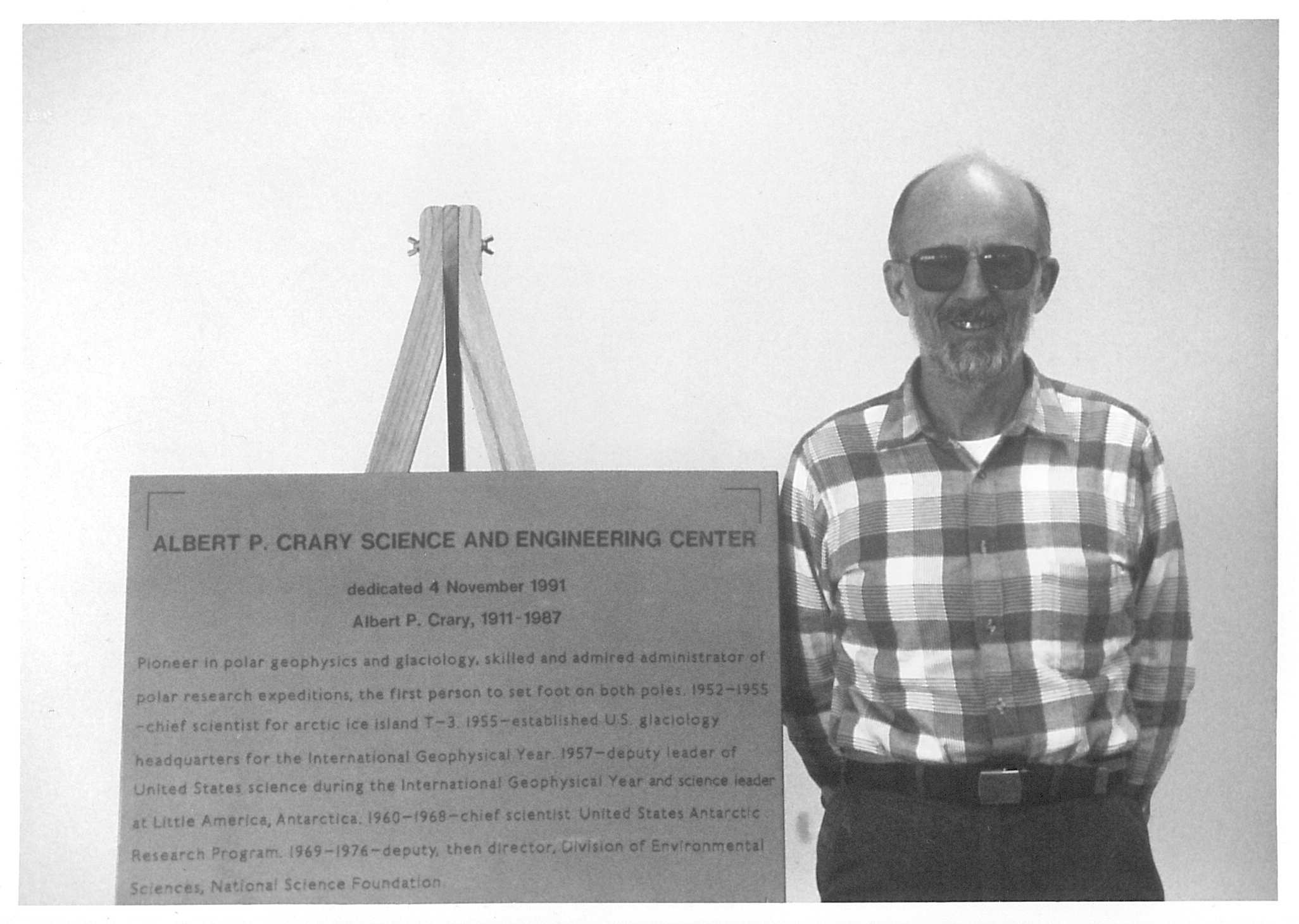 A man standing next to a sign.