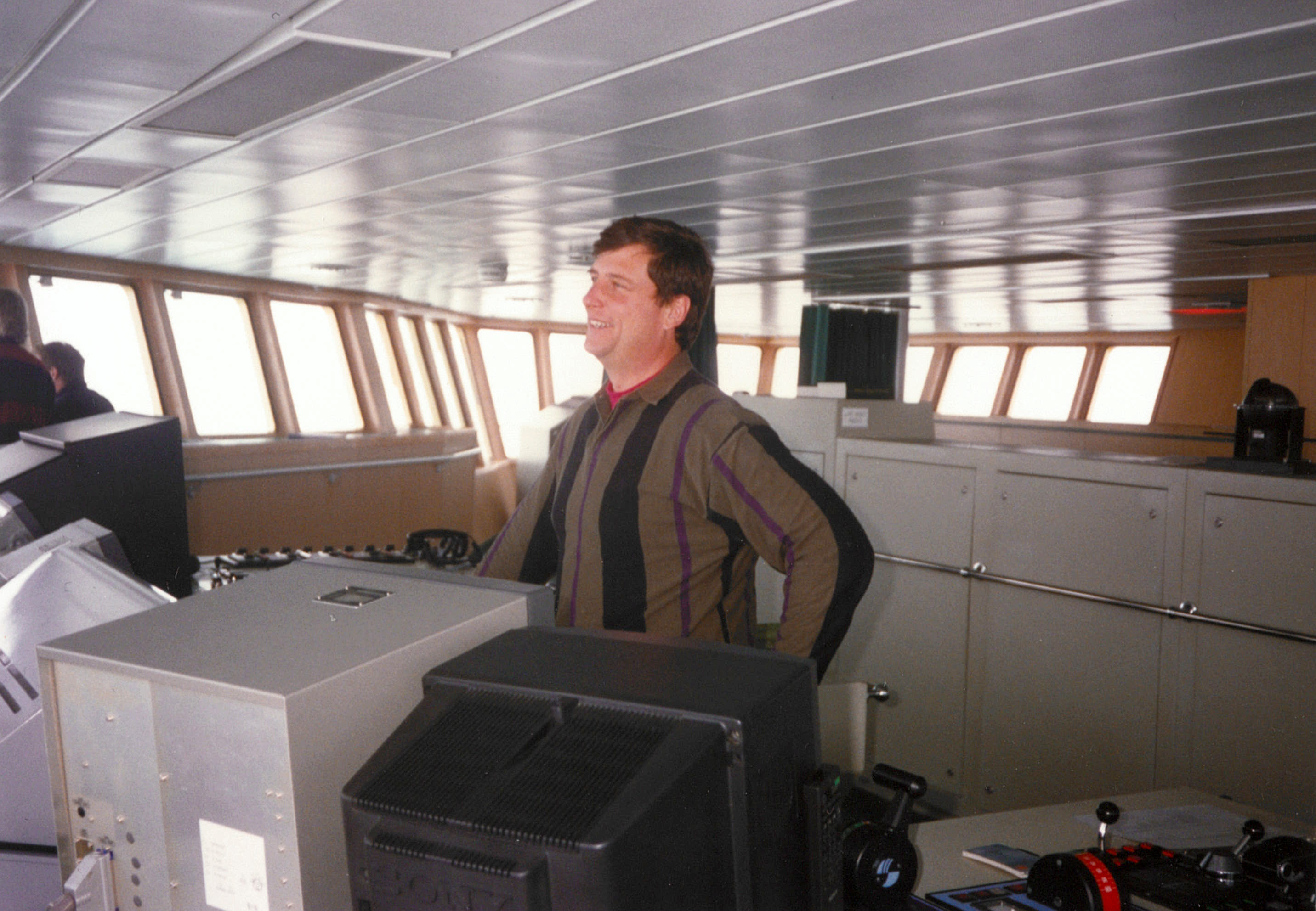 A man stands in the bridge of a ship.