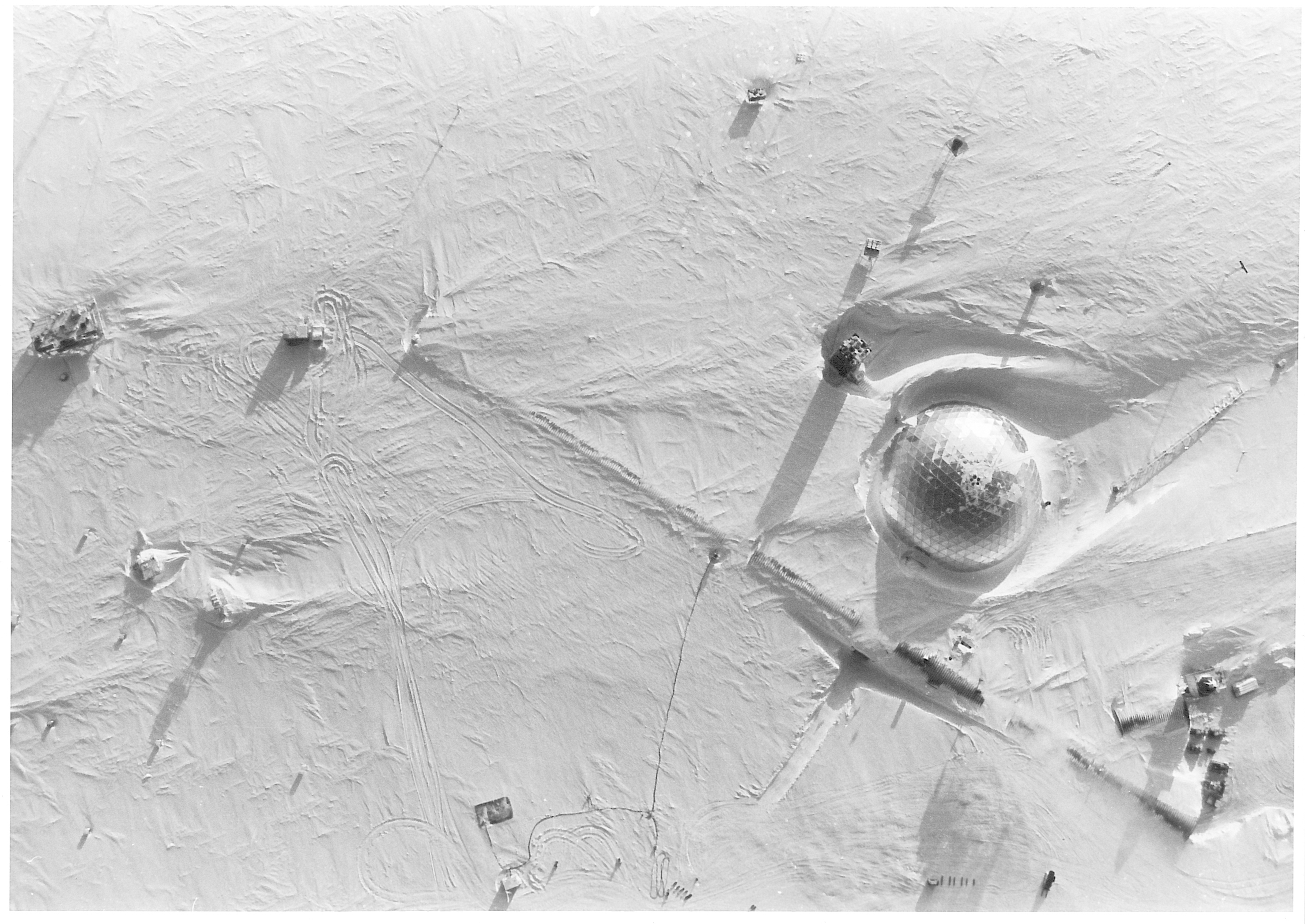 An aerial view of a dome and other structures in the snow.