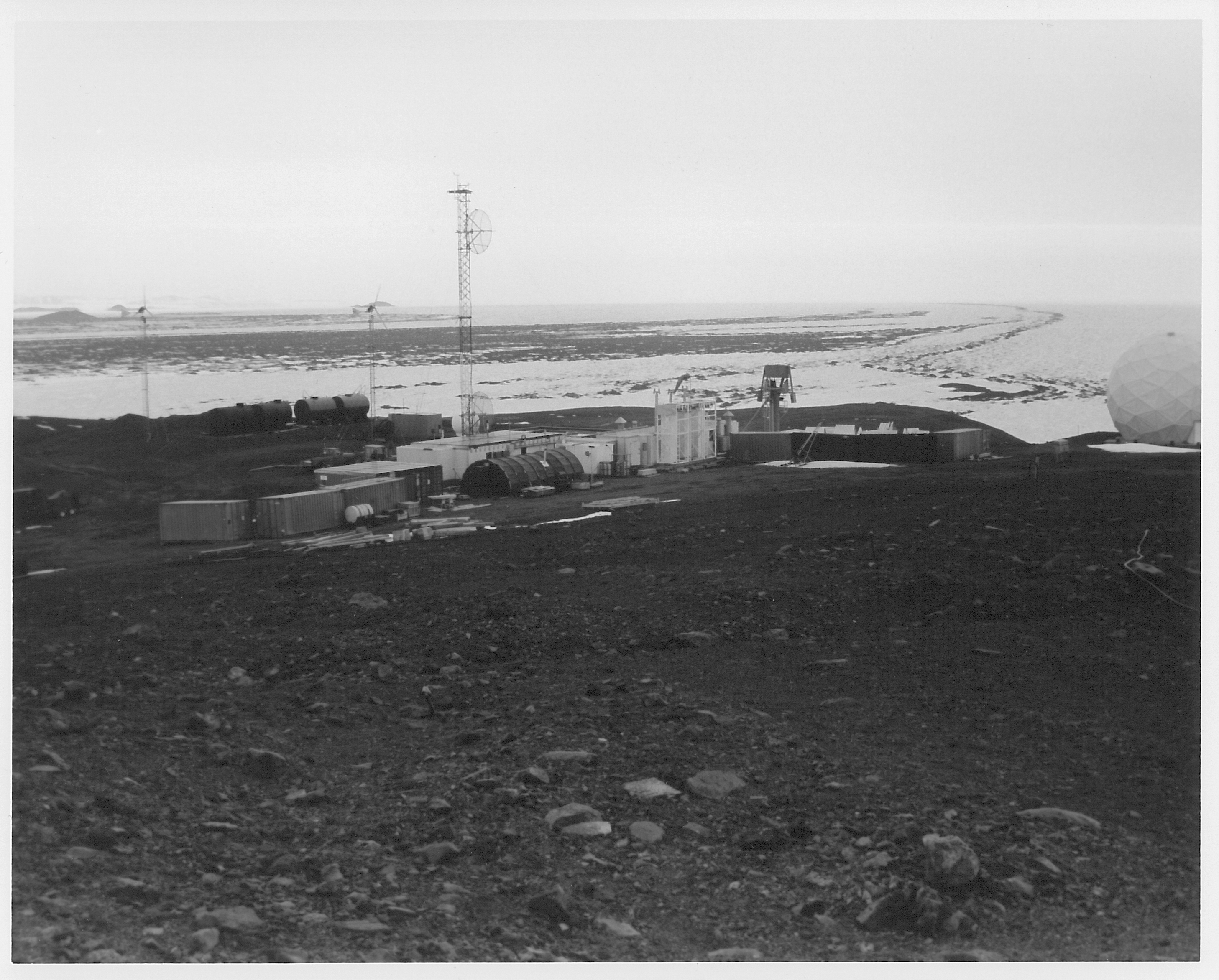 Buildings and antennas on a rocky landscape.