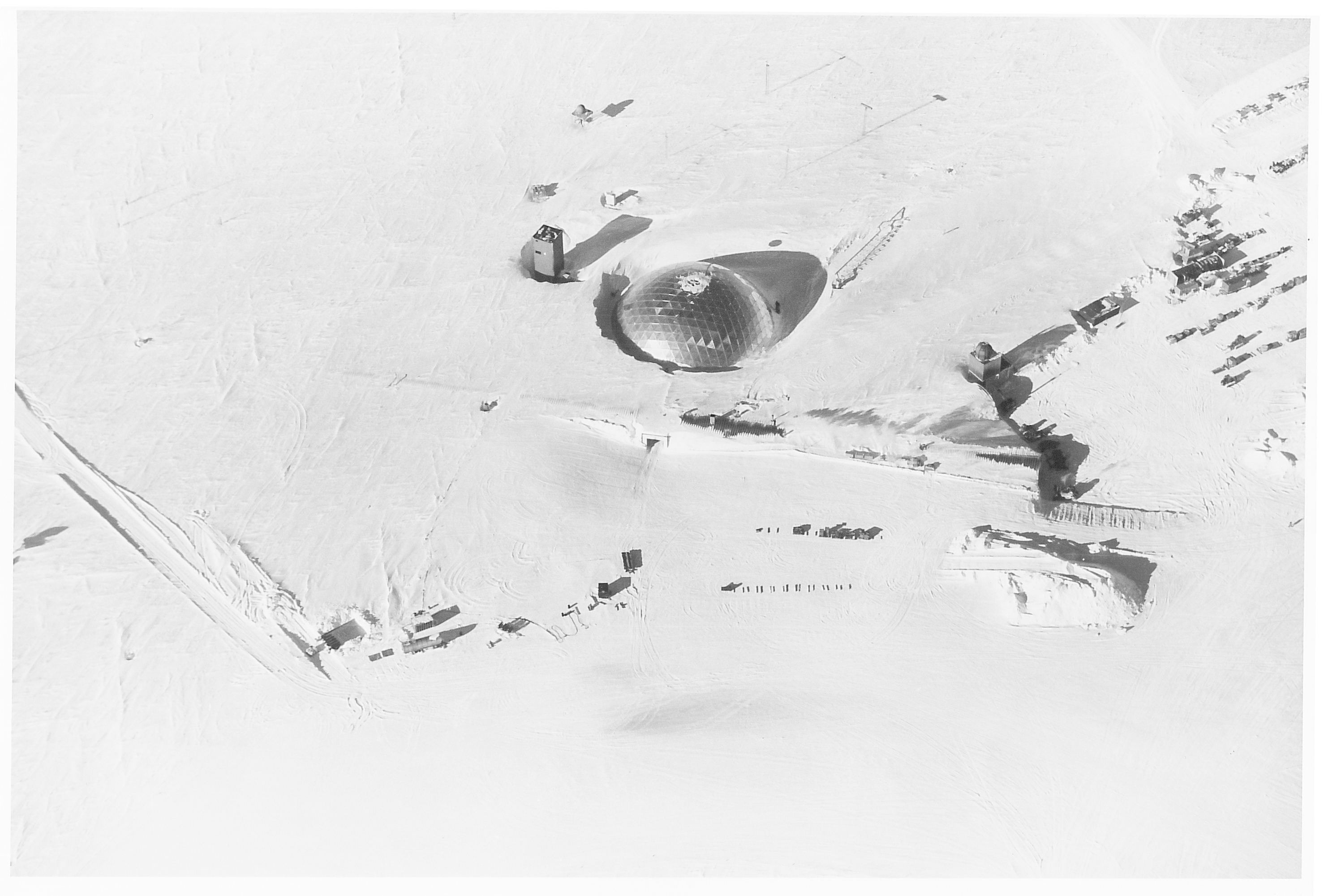 An aerial view of a silver dome and other buildings in the snow.